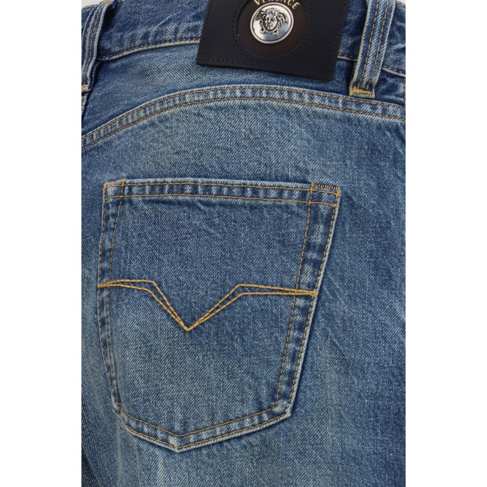 Jeans droits en coton bleu de la marque Versace, visibles avec une coupe classique et détails élégants.