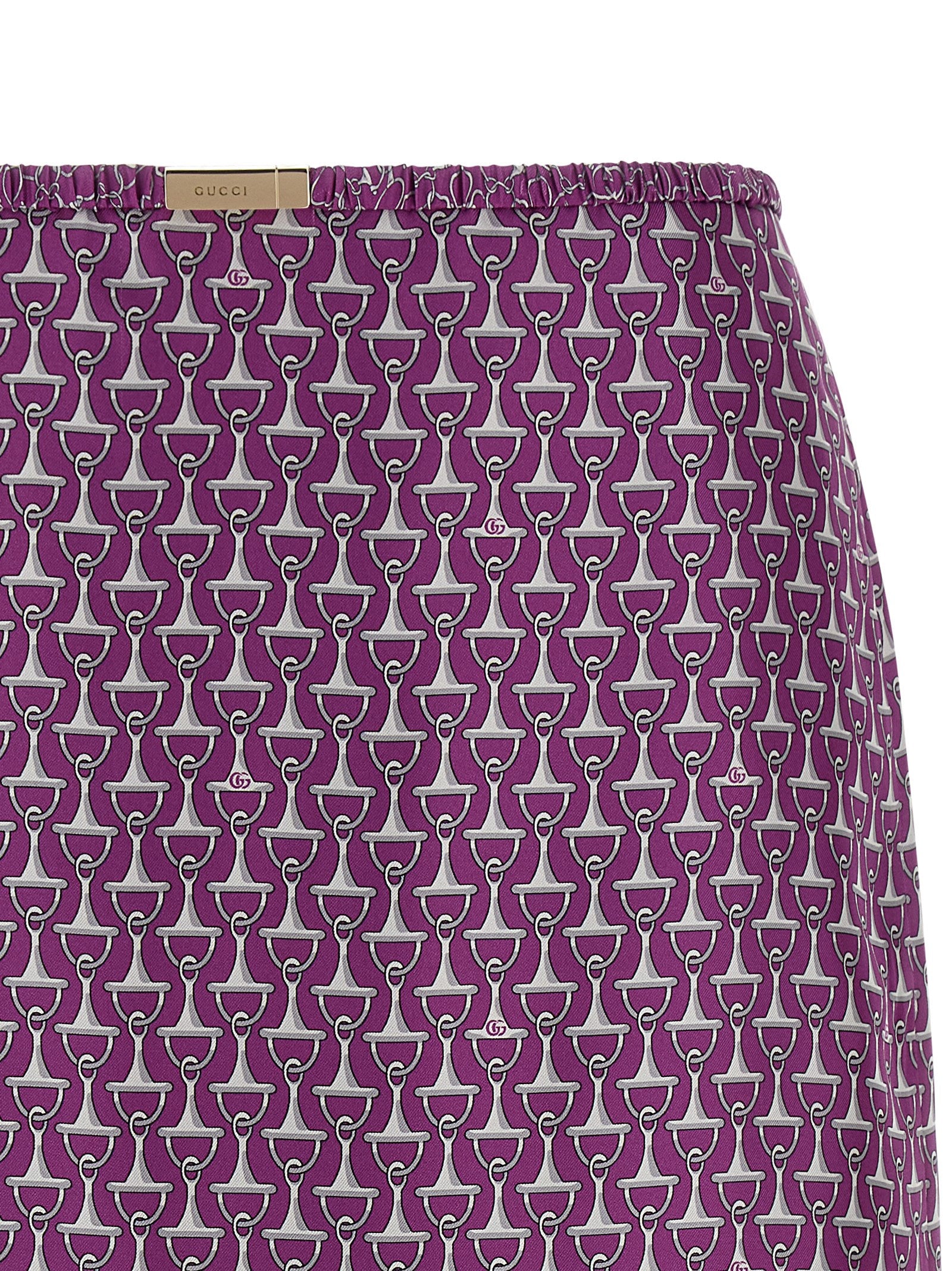 Jupe midi en soie violette Gucci, élégante et fluide, avec détail de couture visible dans l'image.