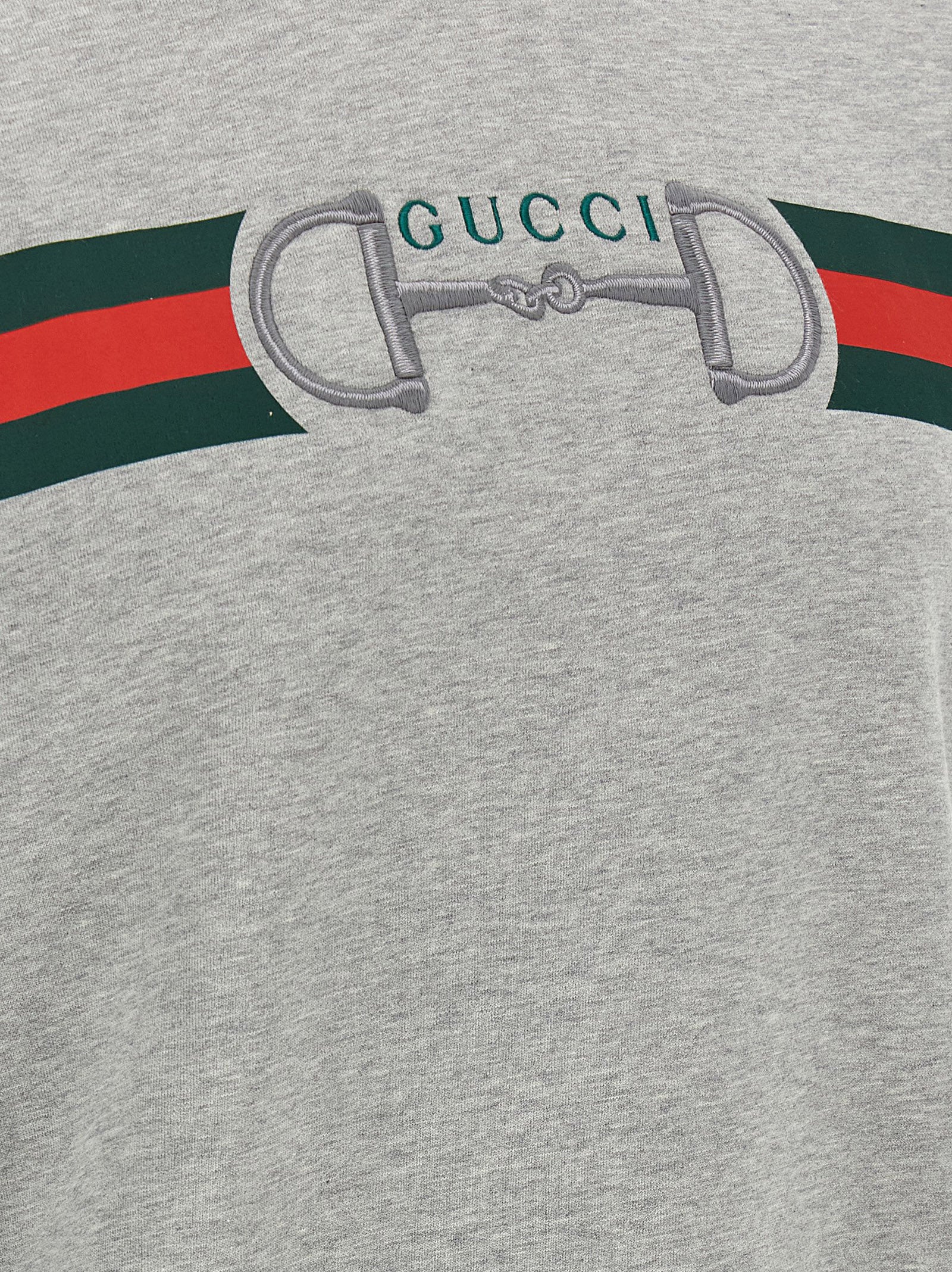 Sweatshirt en coton gris Gucci, vêtement décontracté avec logo Gucci visible sur le devant.