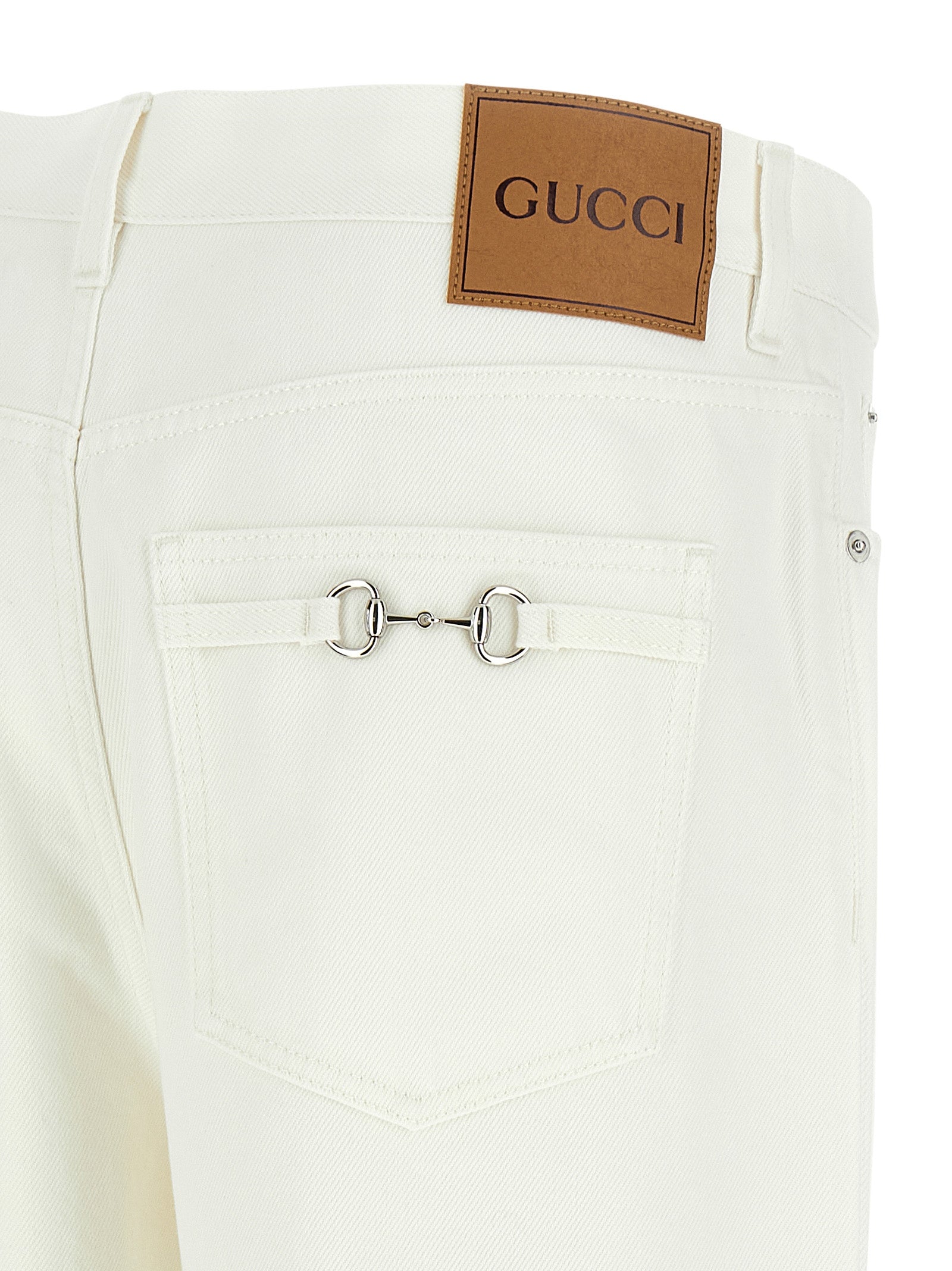 Jean droit en coton blanc de Gucci, style décontracté, avec détails classiques, visible sur un mannequin.