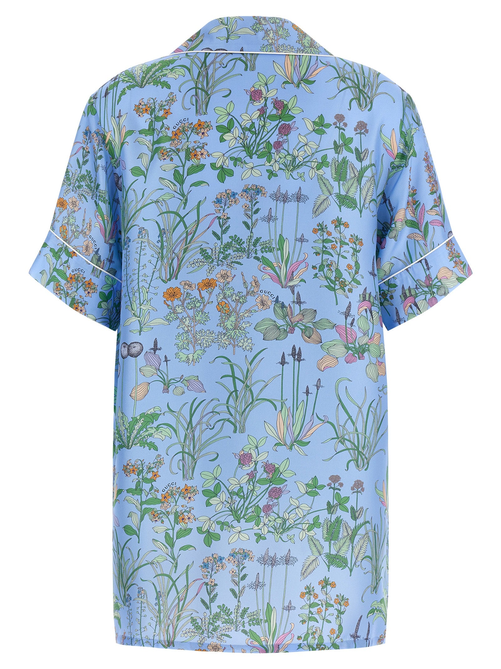 Blouse en soie bleue Gucci pour femme, coupe élégante et tissu fluide, portée avec col et manches longues.