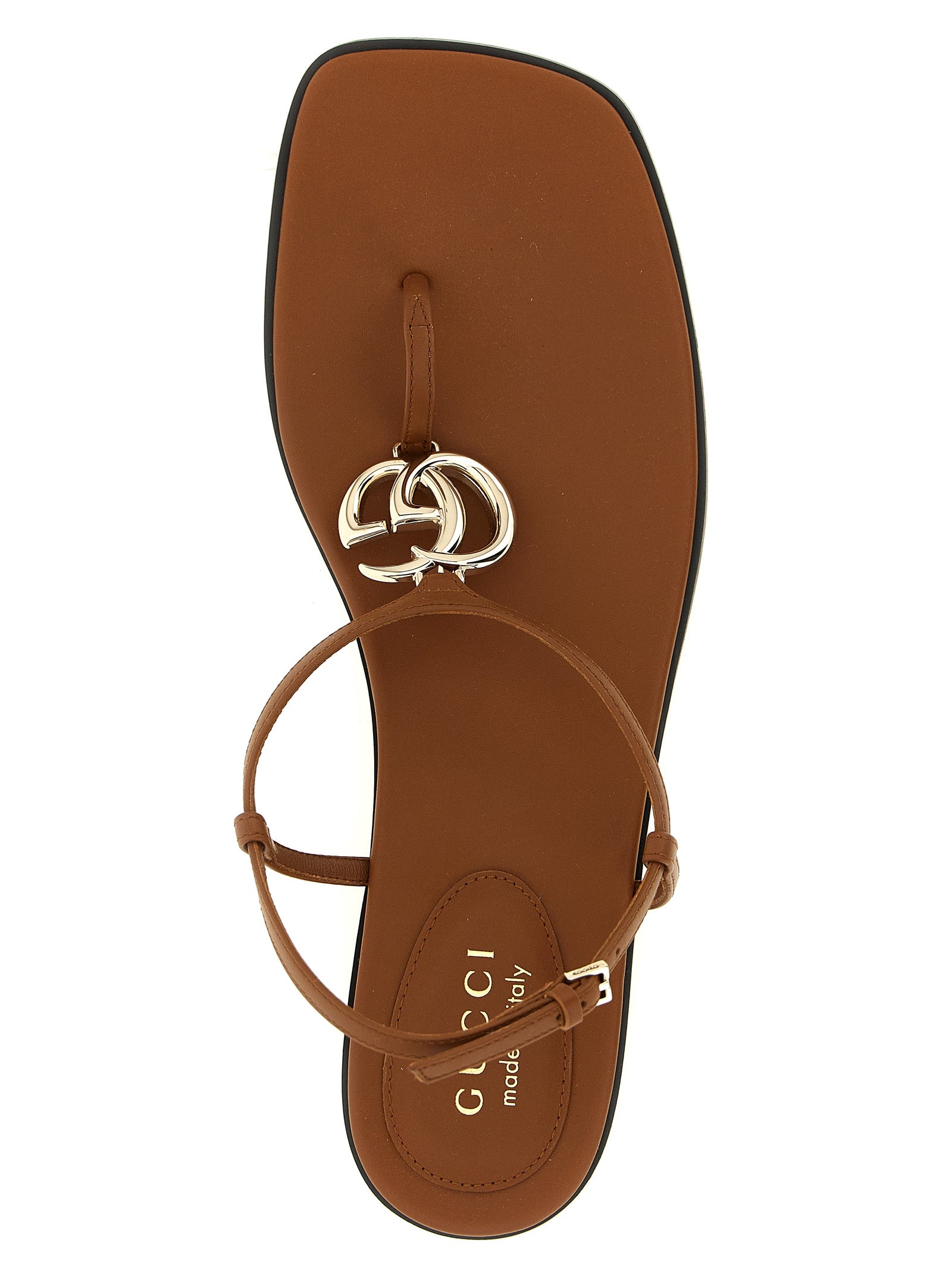 Sandales plates en veau brun de Gucci, style élégant, avec bride fine et finition soignée, vue de côté.