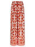 Pantalons évasés en soie orange de Dolce & Gabbana, style élégant et fluide, vue détaillée de la matière et de la coupe.