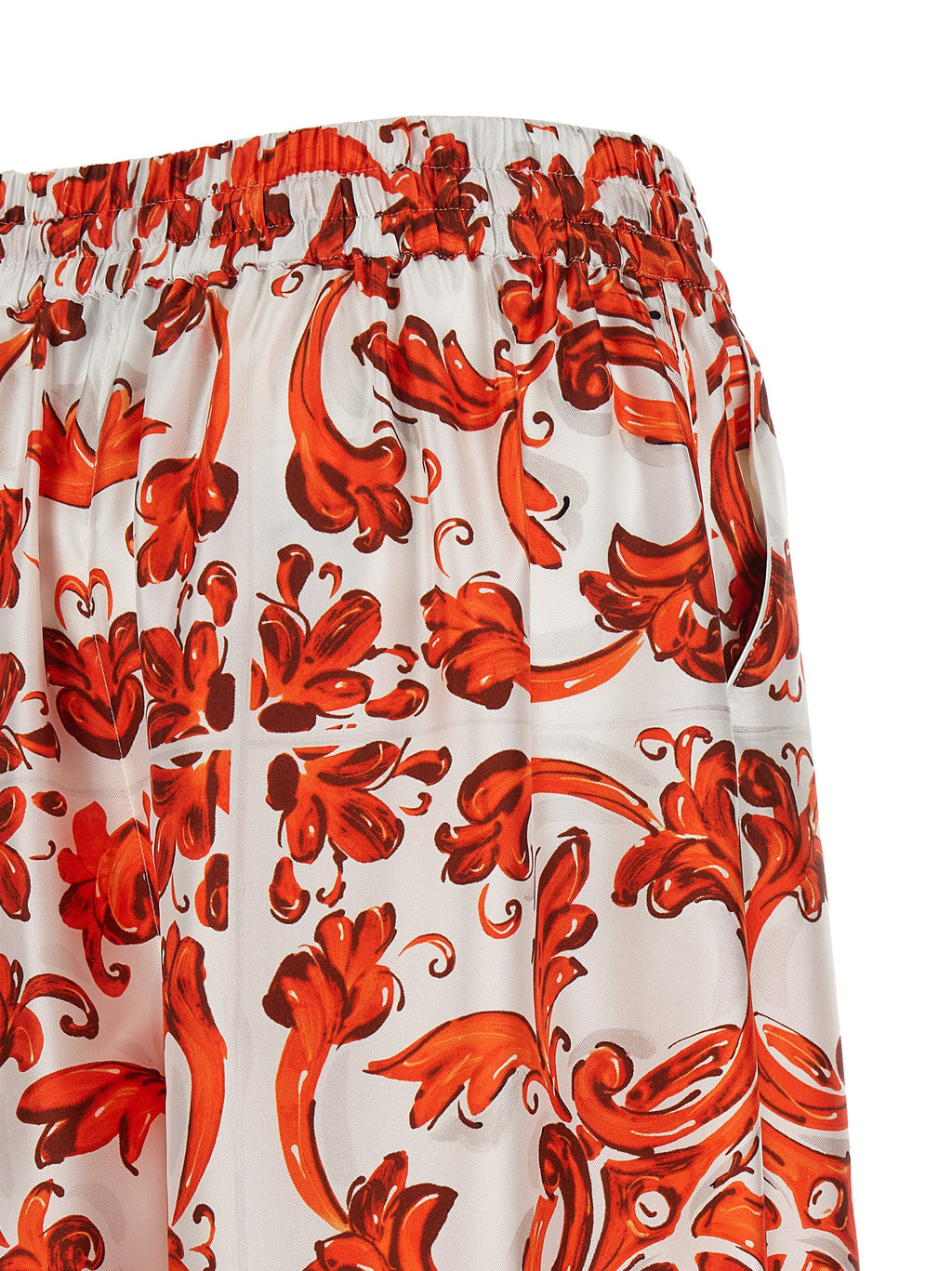 Pantalons évasés en soie orange de Dolce & Gabbana, style élégant et fluide, visibles en détail sur l'image.