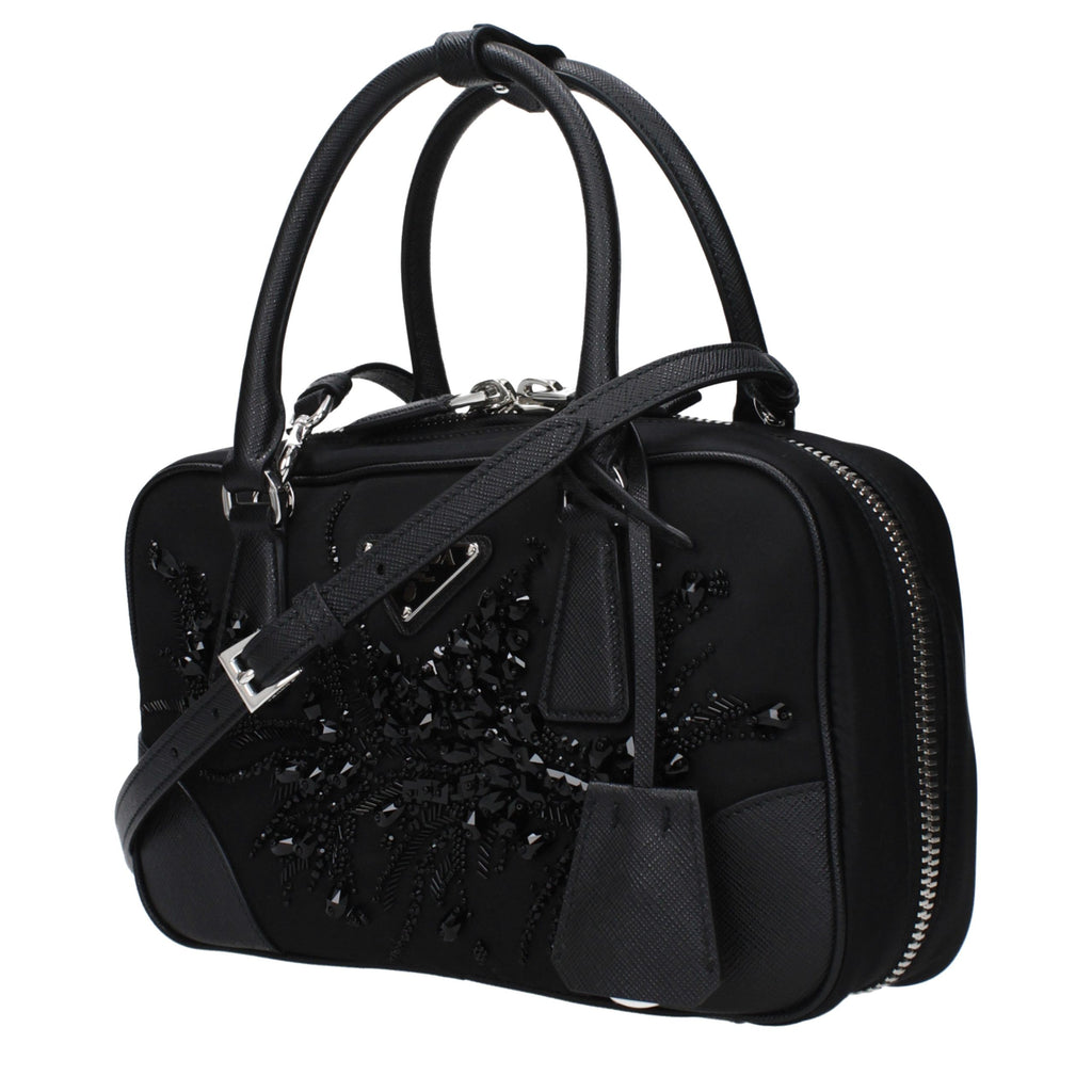 Sac à main en tissu noir de Prada, élégant et sophistiqué, avec détails en cuir et logo Prada visible sur le devant.