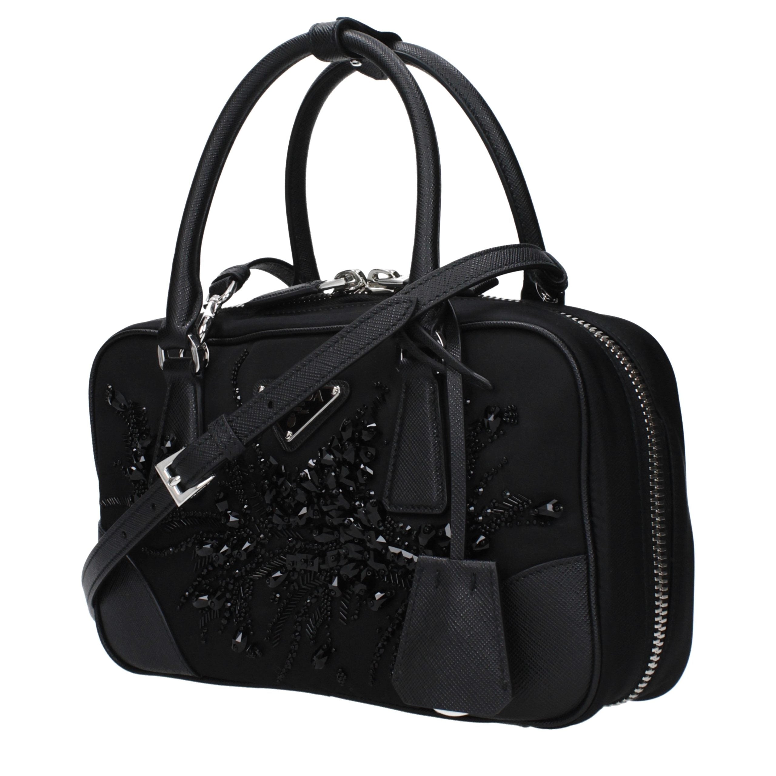 Sac à main en tissu noir de Prada, élégant et sophistiqué, avec détails en cuir et logo Prada visible sur le devant.