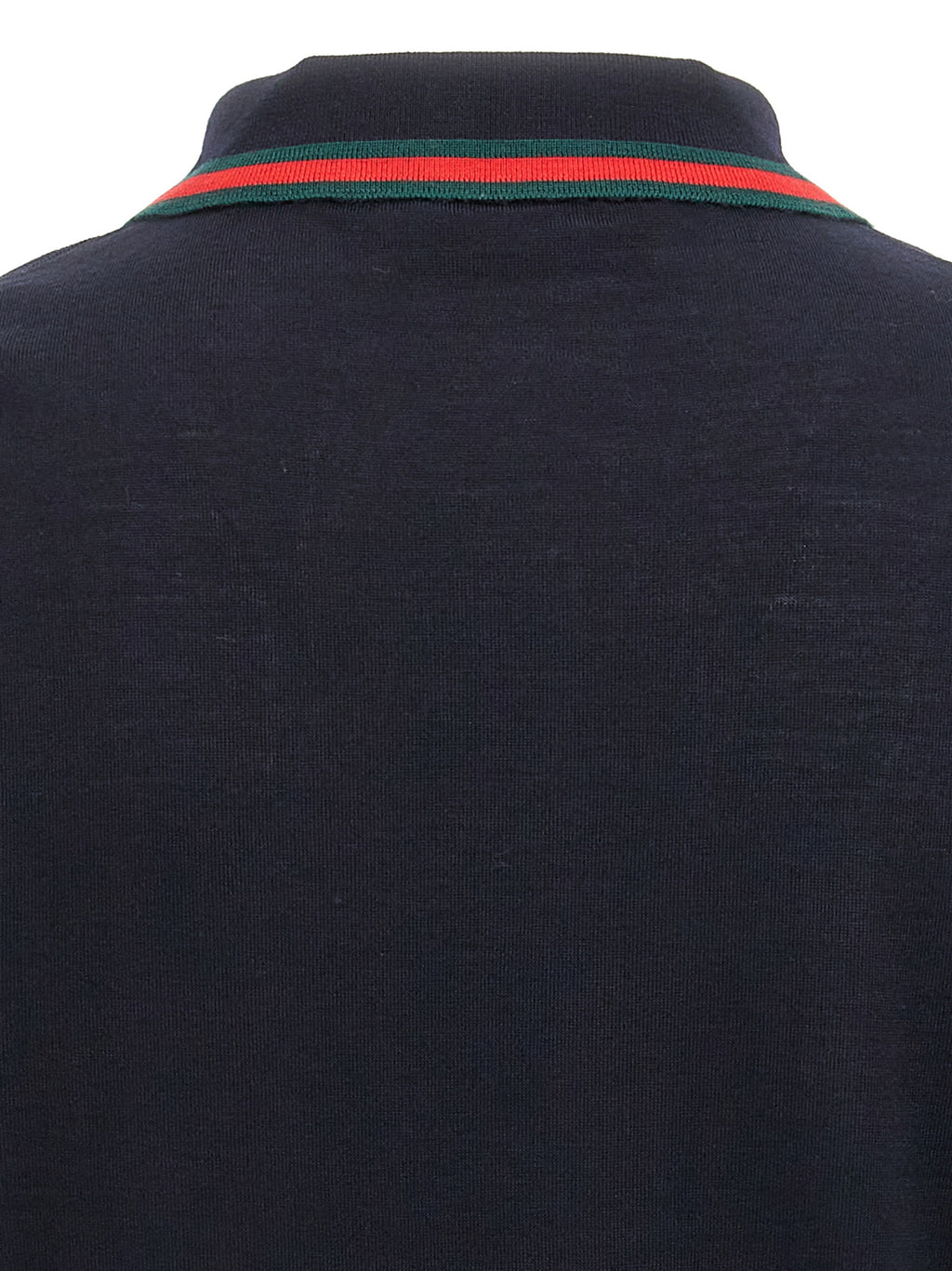 Chemise polo en laine bleue de Gucci, vue détaillée du vêtement avec col et logo Gucci visible.
