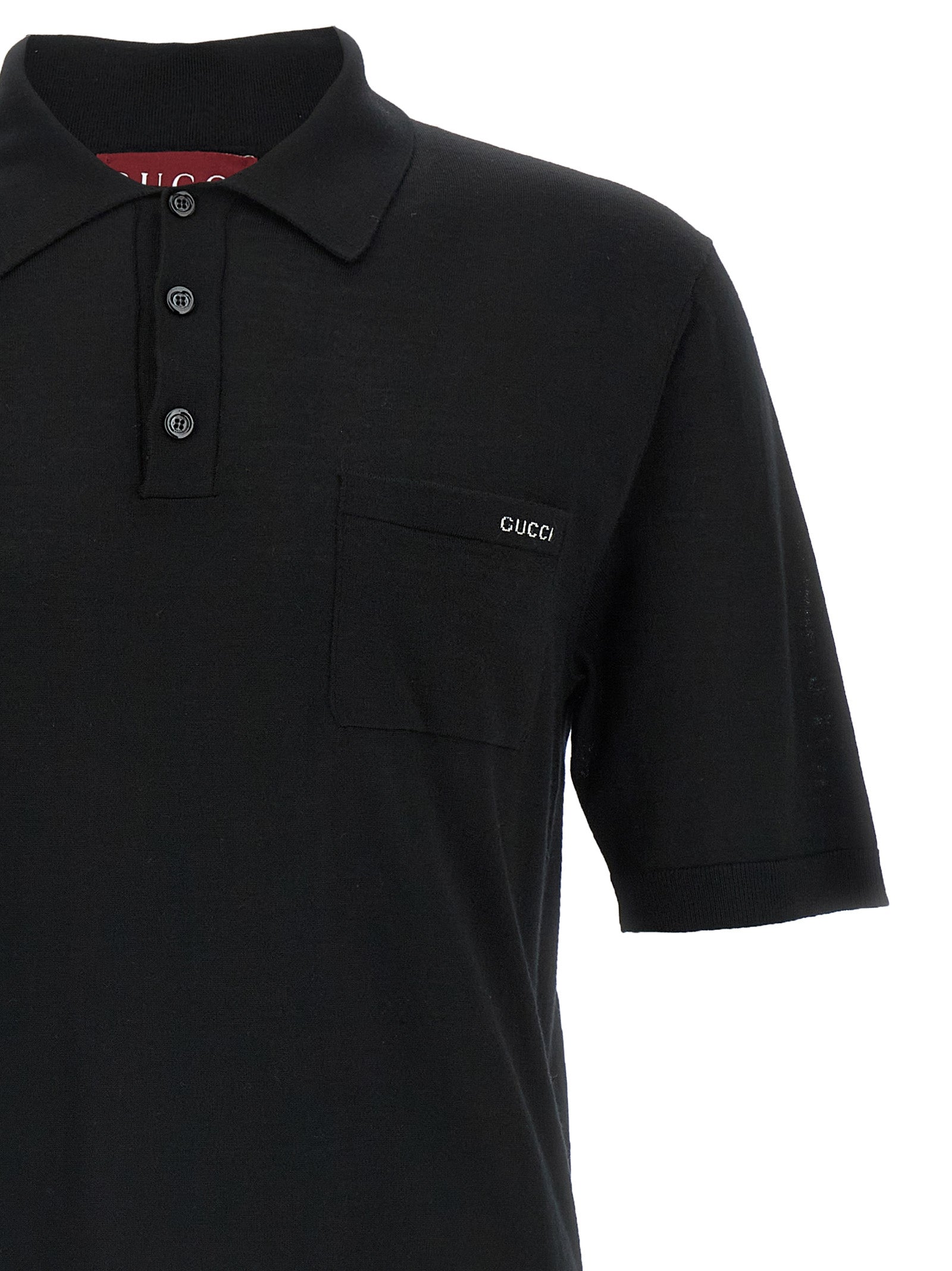 Chemise polo en laine noire Gucci, vue de face, détail du col et du logo Gucci sur la poitrine.