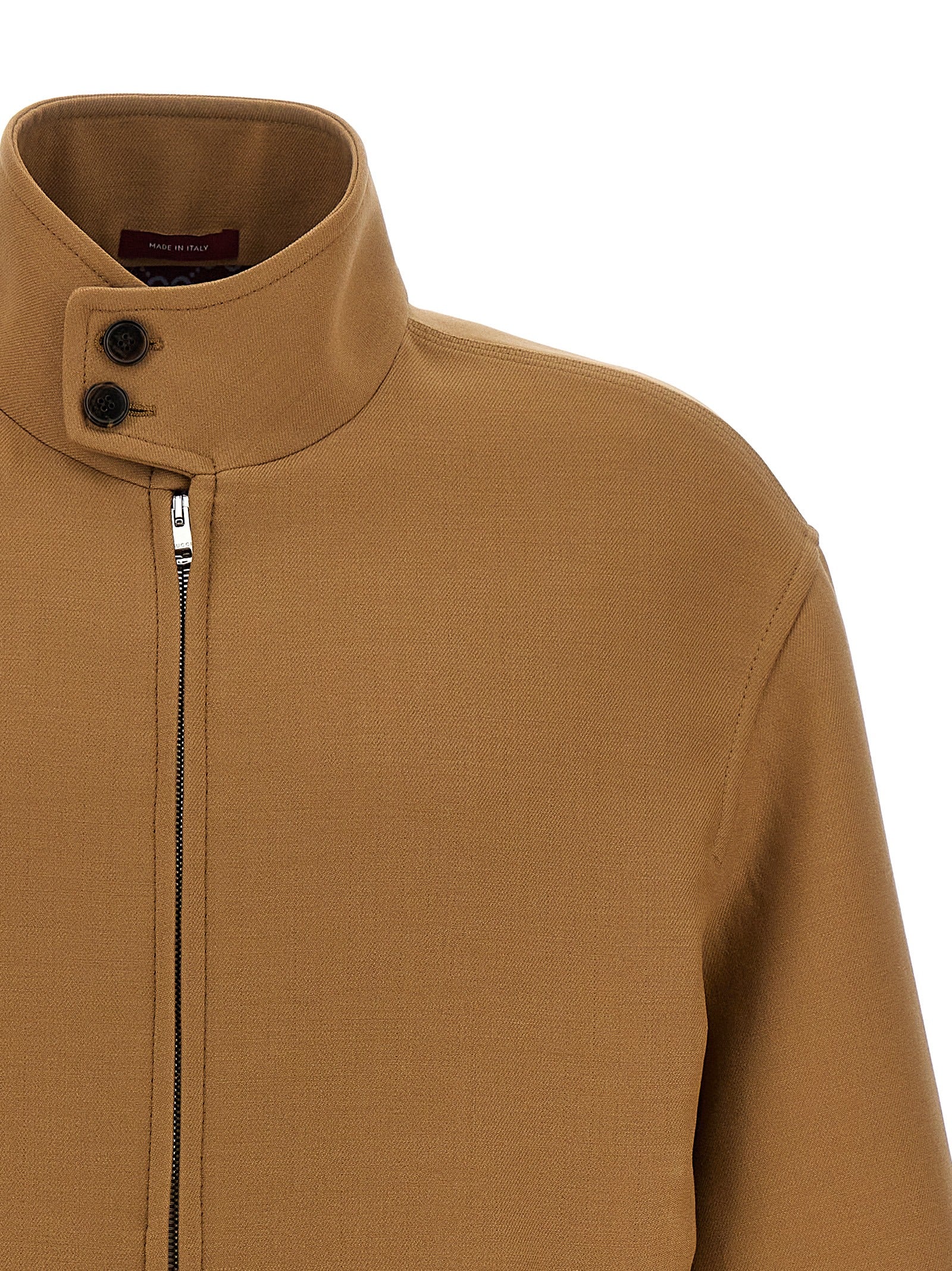 Veste longue en laine marron Gucci, coupe élégante et sophistiquée, visible sur un mannequin avec détails de couture.