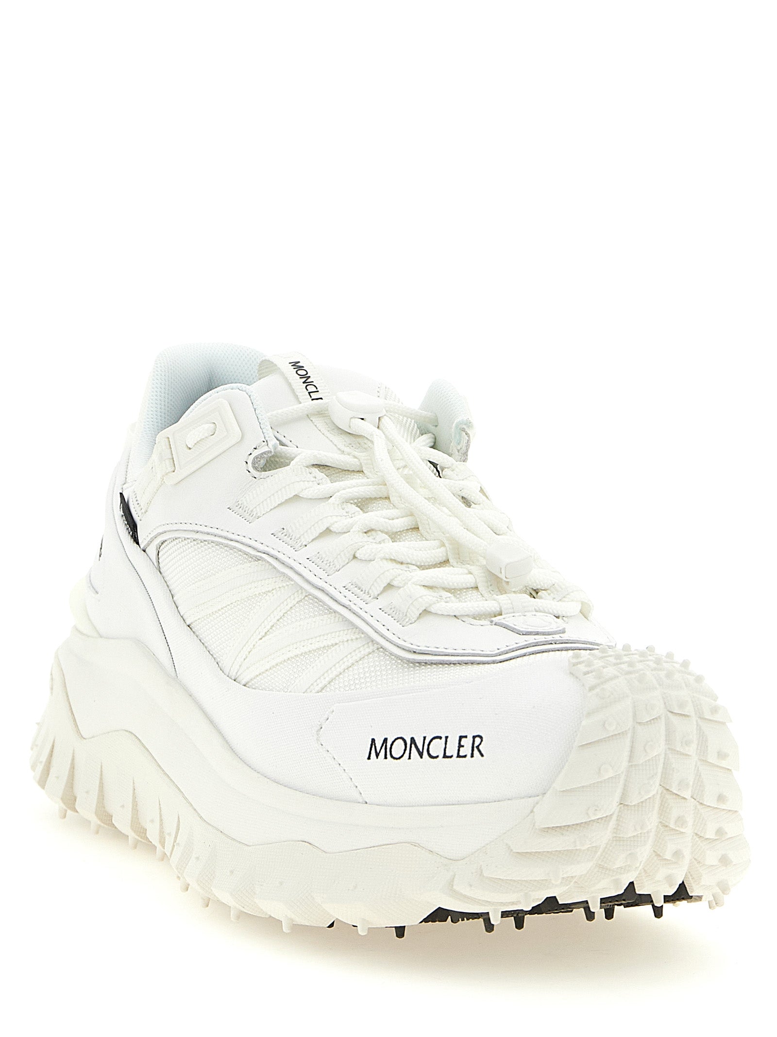 Chaussures de sport blanches Moncler en cuir, sneakers athlétiques élégants et confortables, visibles en gros plan.
