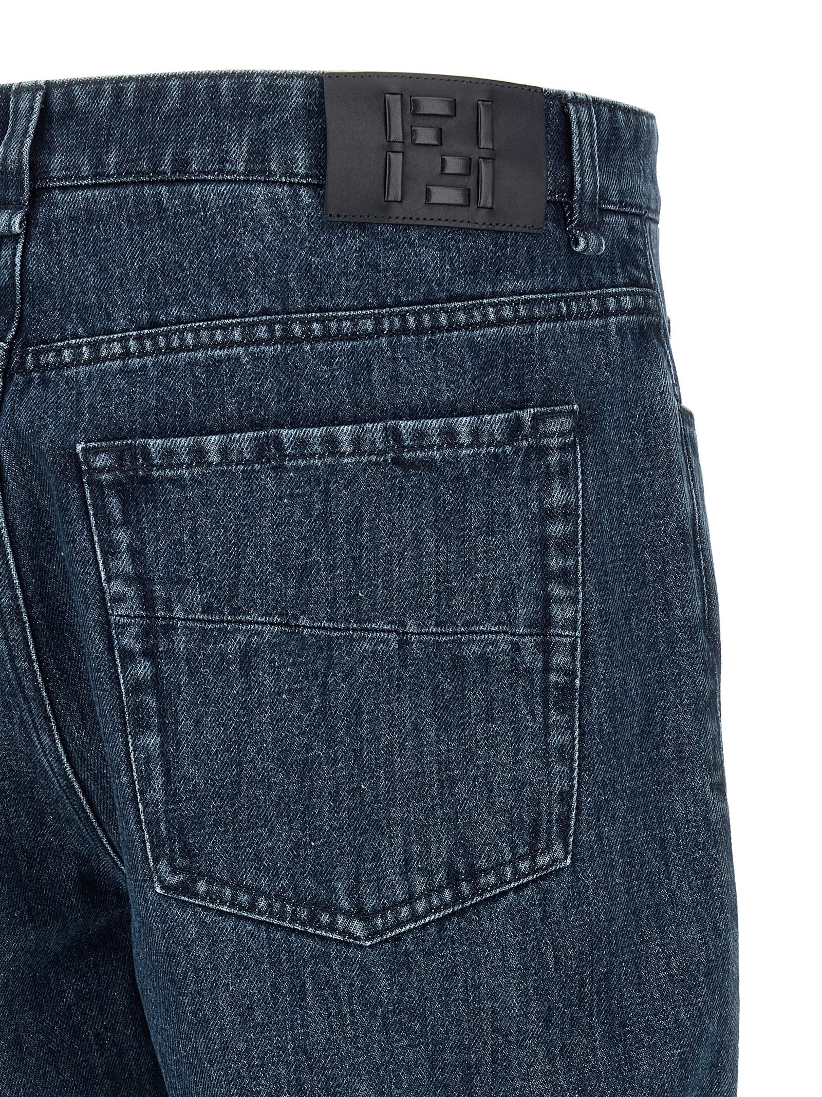 Jeans évasés en coton bleu Fendi, style décontracté avec coupe flare, visibles sur la photo.