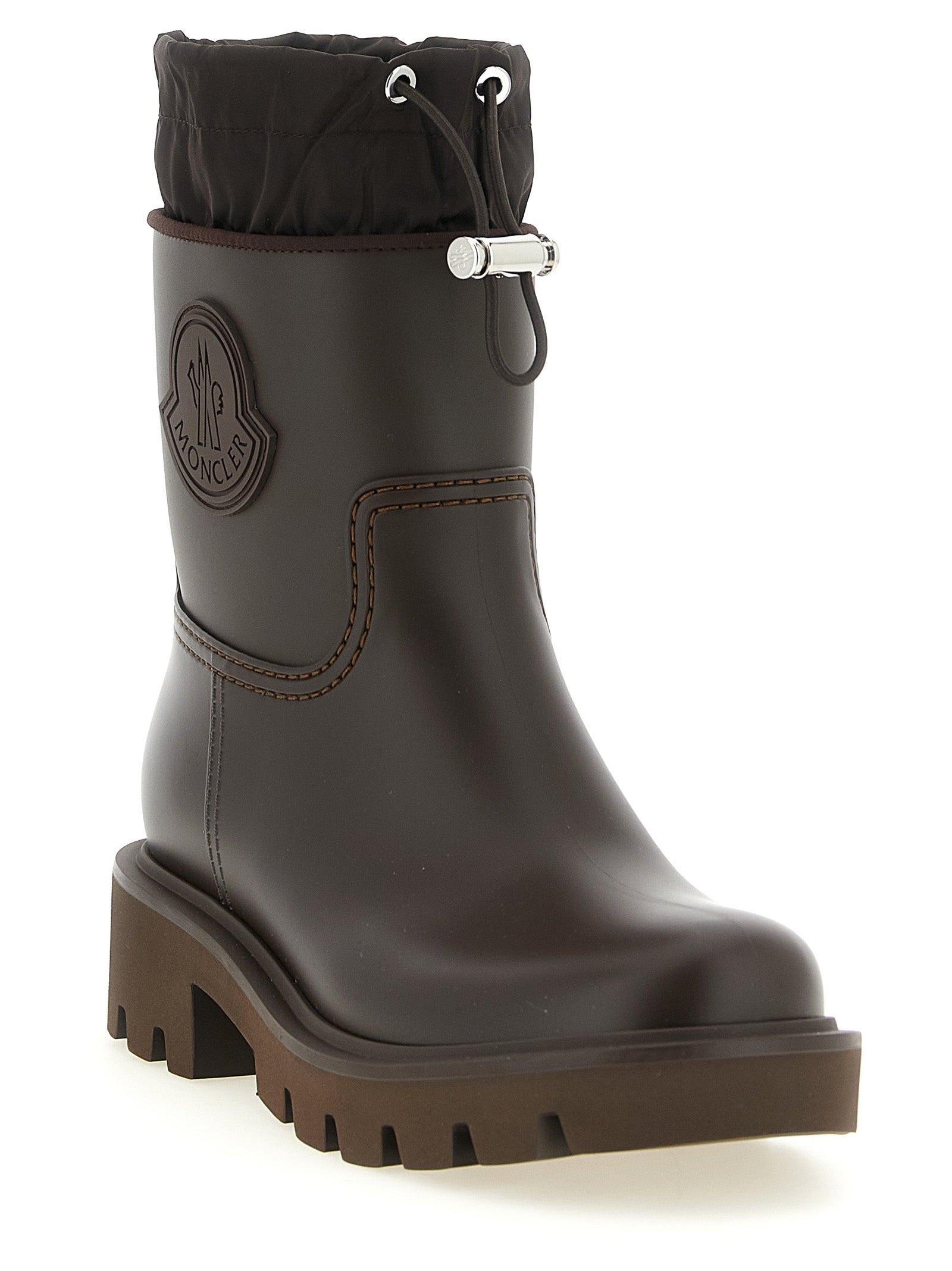 Bottes montantes en PVC marron Moncler pour femme, style élégant et résistant à l'eau, visibles sur fond neutre.