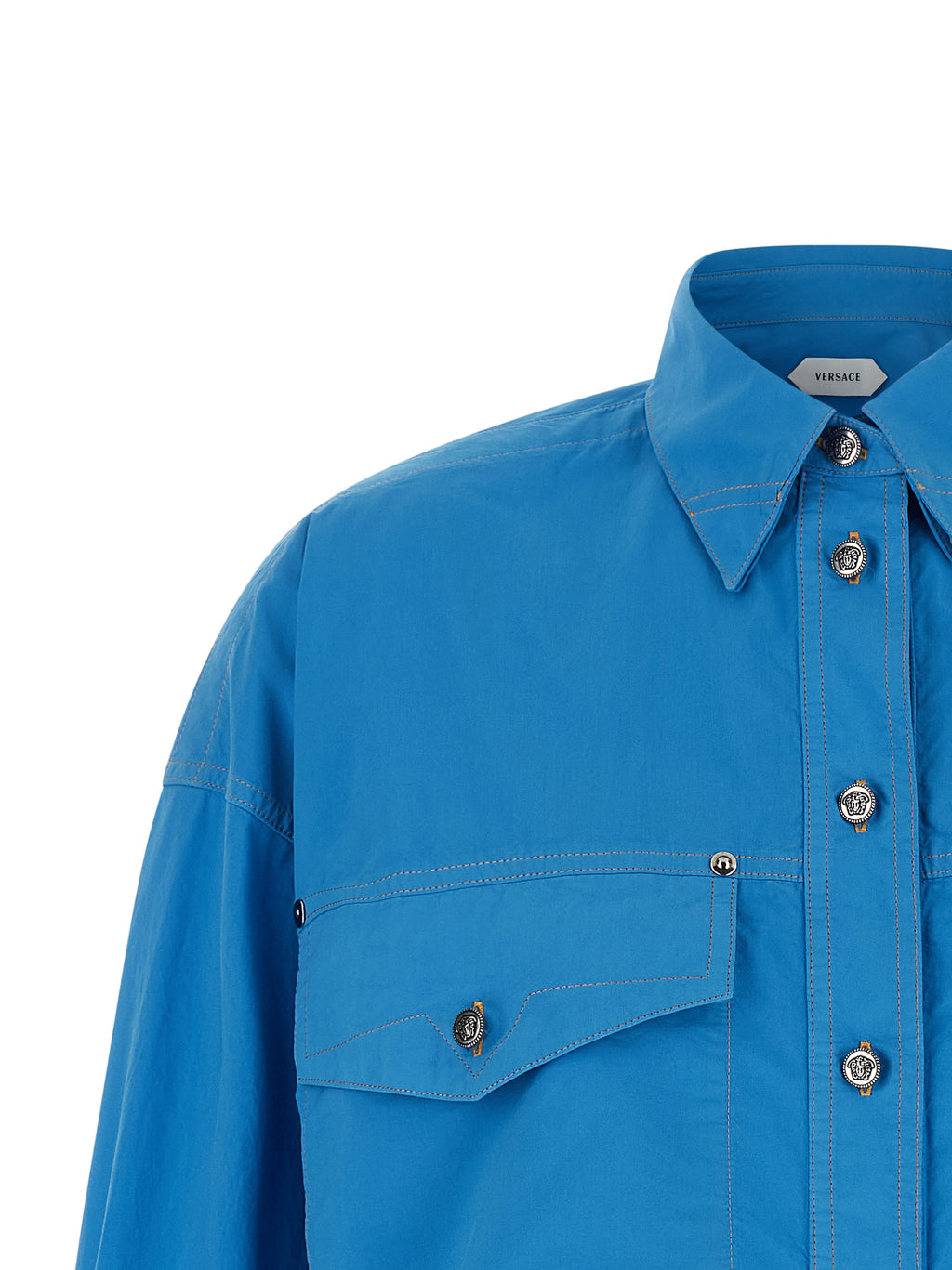 Chemise en coton bleue Versace avec logo emblématique, manches longues et coupe élégante.