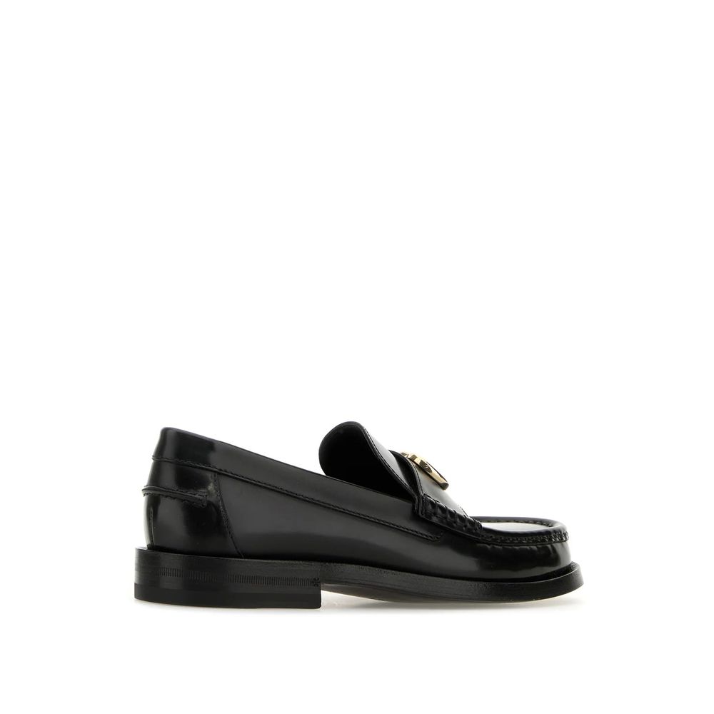 Mocassins Gucci en cuir noir pour homme, style slip-on avec semelle en cuir et design élégant.