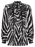 Blouse en soie bicolore Dolce & Gabbana élégante, avec col et manches longues, portée chic et sophistiquée.