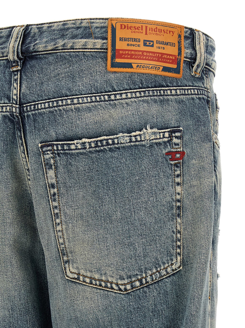 Jeans Diesel en coton bleu coupe tapered, visibles avec détails et texture du tissu dans une image claire.