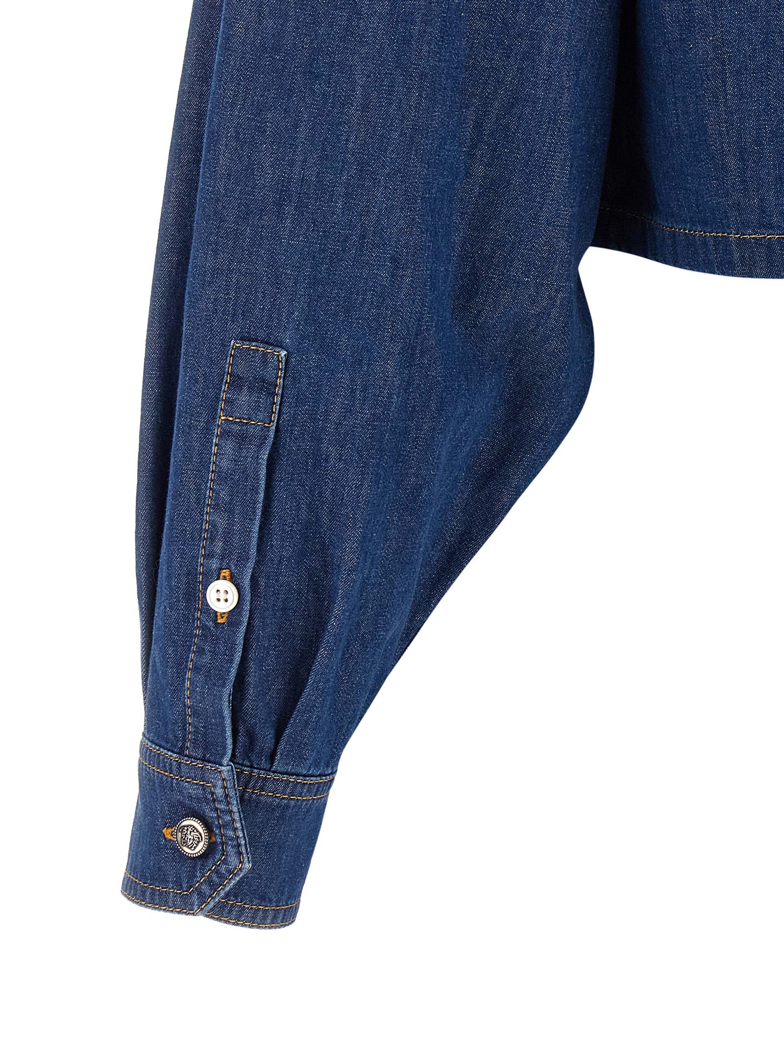 Chemisier en coton bleu de la marque Versace, avec détails élégants visibles sur l'image.