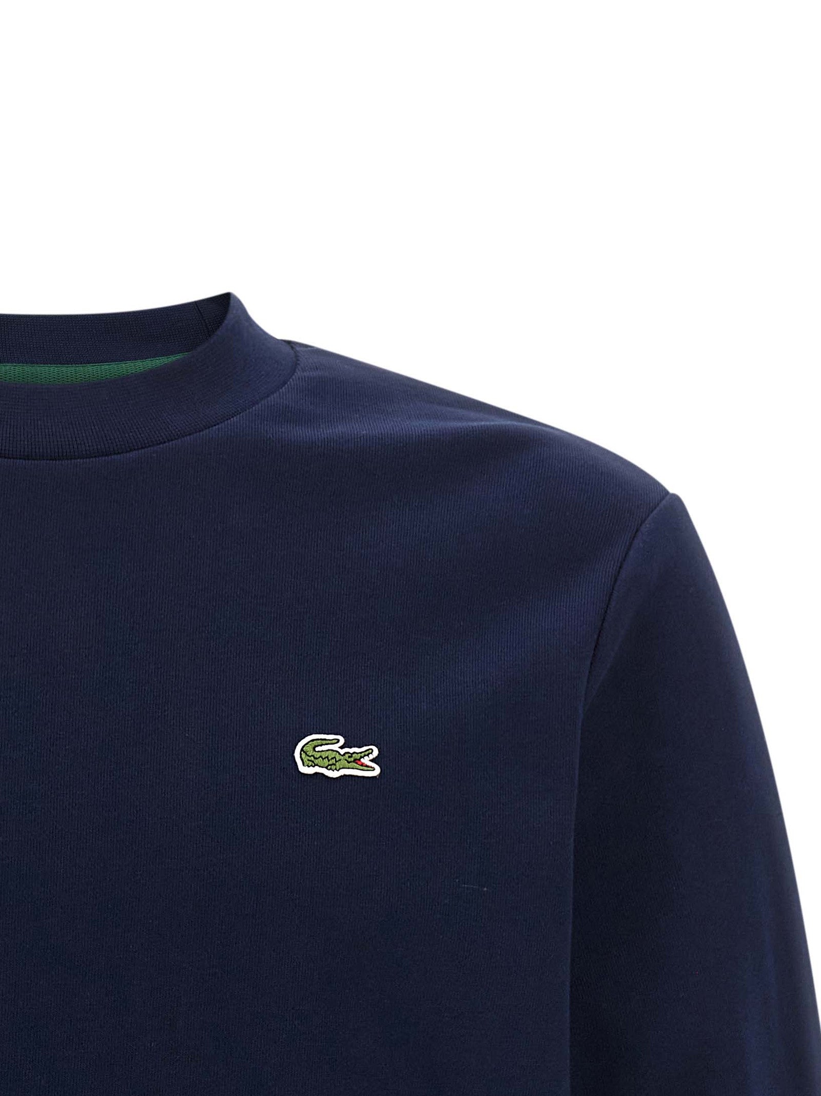 Sweat-shirt en coton bleu Lacoste, style décontracté avec logo crocodile sur la poitrine, porté sur un mannequin.