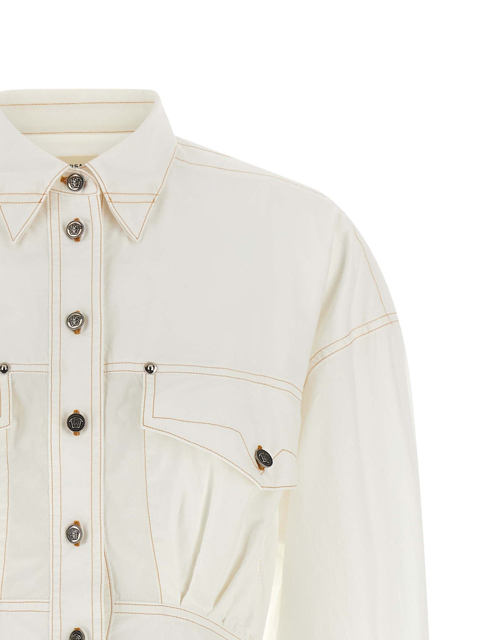 Robe courte en coton blanc de Versace, élégante et légère, avec un design sophistiqué et des détails raffinés.