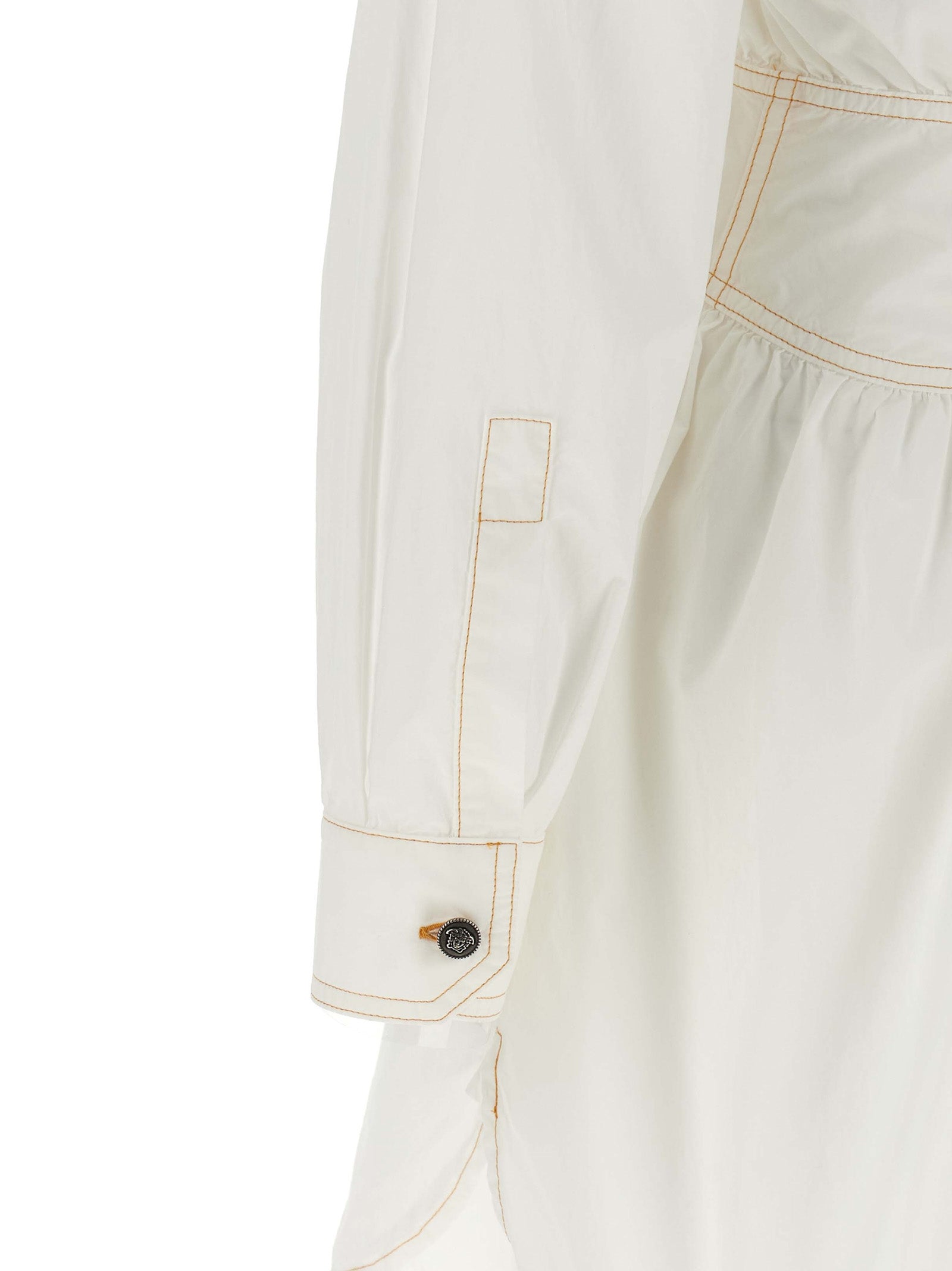 Robe courte en coton blanc de Versace, élégante et légère, avec détails sophistiqués visibles sur l'image.