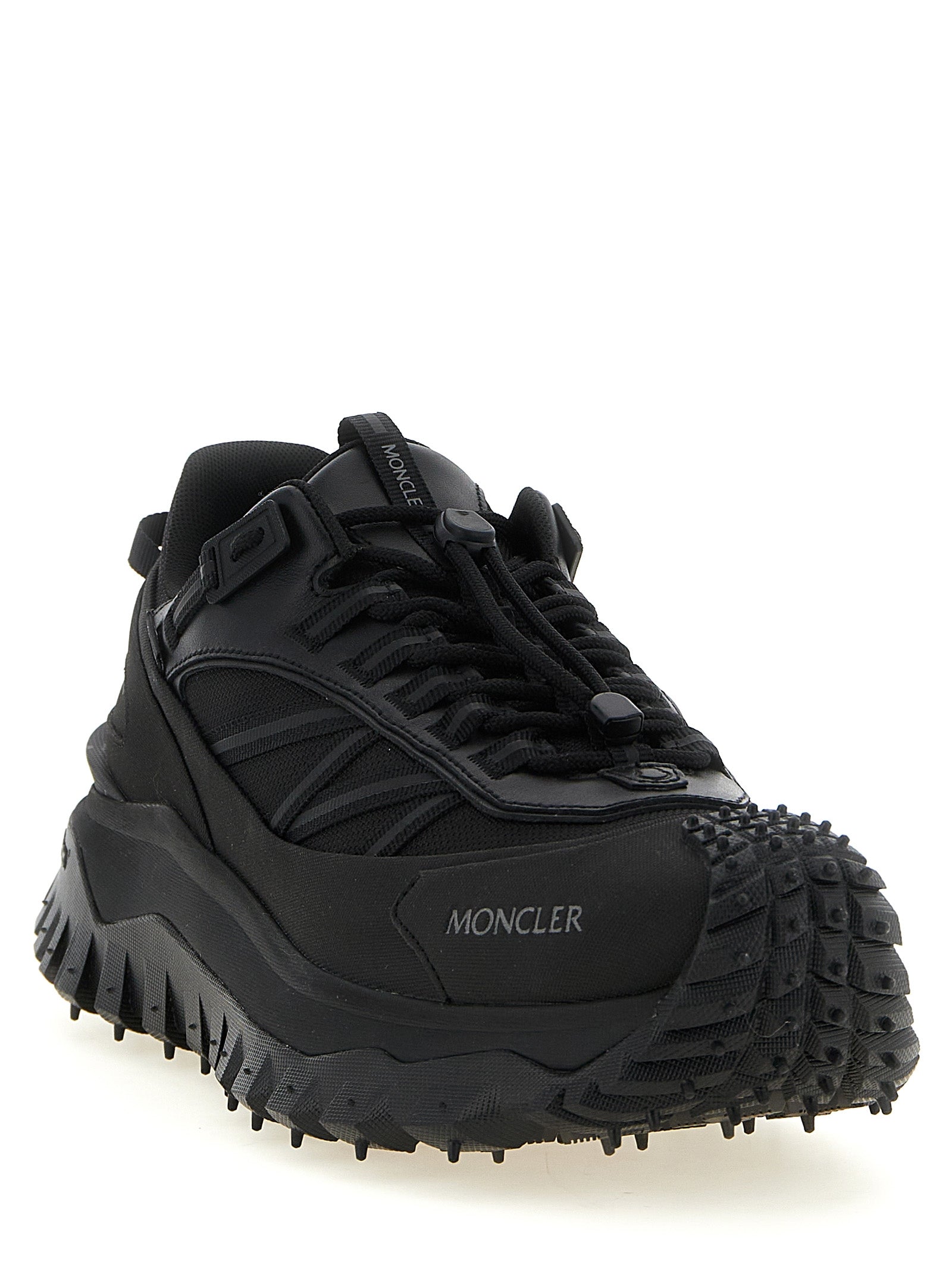 Chaussures de sport en cuir noir Moncler, baskets athlétiques élégantes, détails de la marque et semelle confortable visibles.