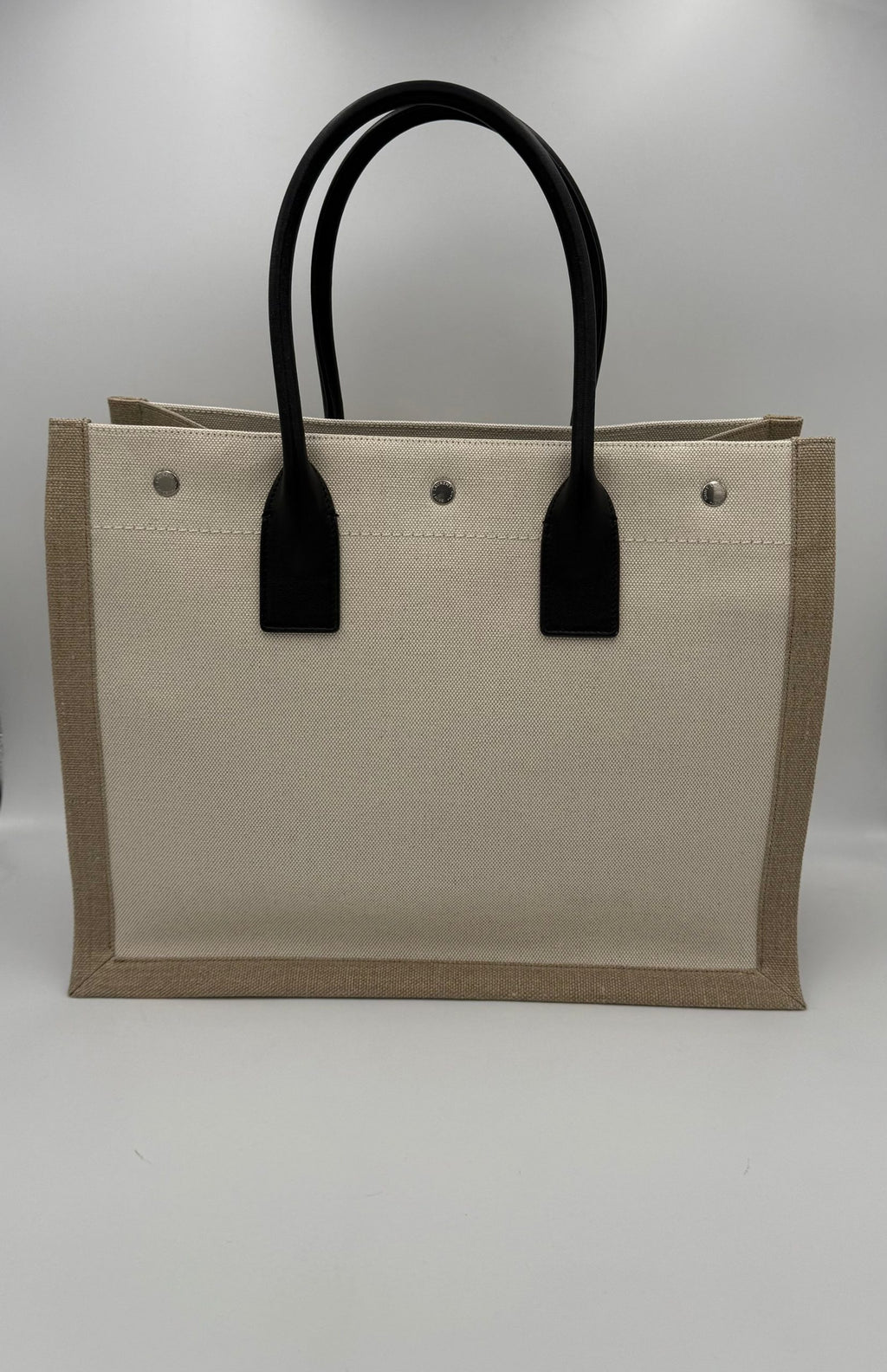 Sac moyen Saint Laurent Rive Gauche en toile noire avec poignées en cuir et logo doré.