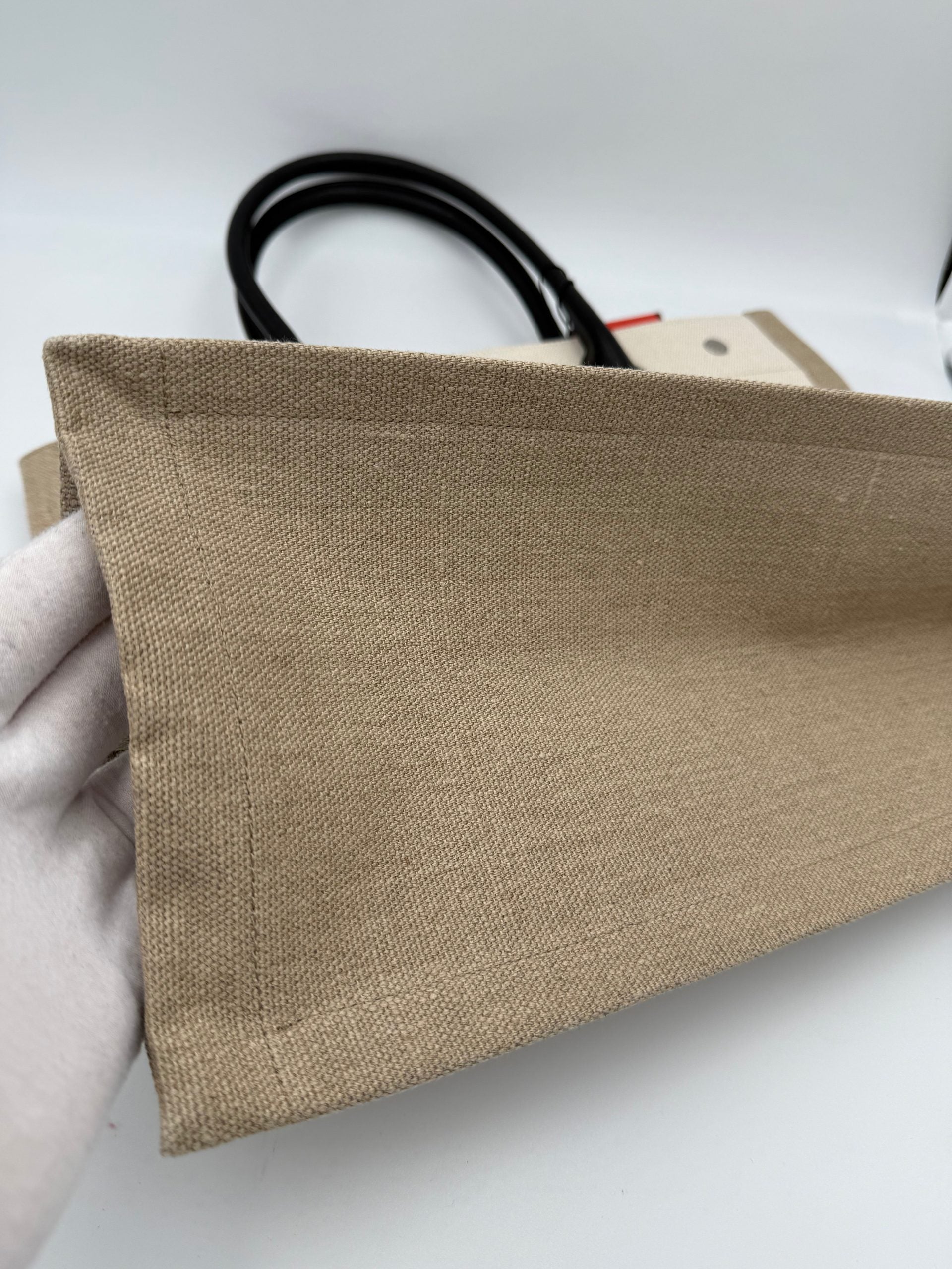 Sac cabas moyen Saint Laurent Rive Gauche en cuir noir avec logo en métal, porté ou posé sur une surface élégante.