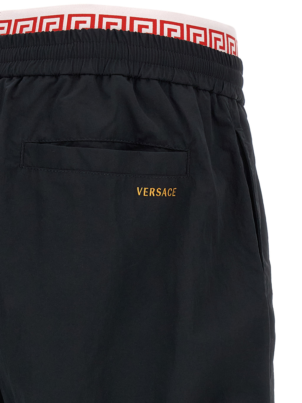 Pantalons de jogging noirs Versace en polyamide, style décontracté, avec logo Versace visible sur la jambe.