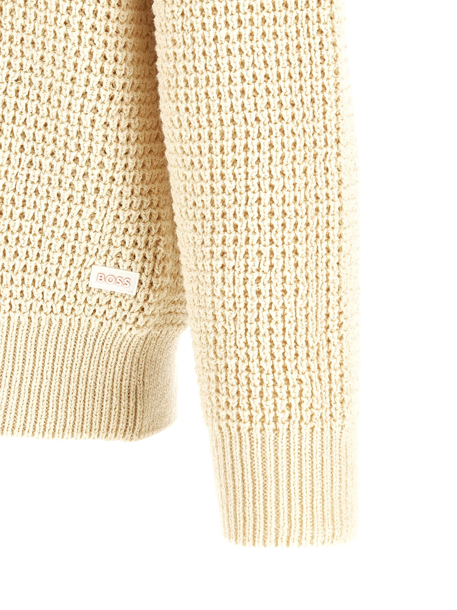 Cardigan beige en coton de la marque Hugo Boss, avec boutons et col en V, porté sur un mannequin blanc.