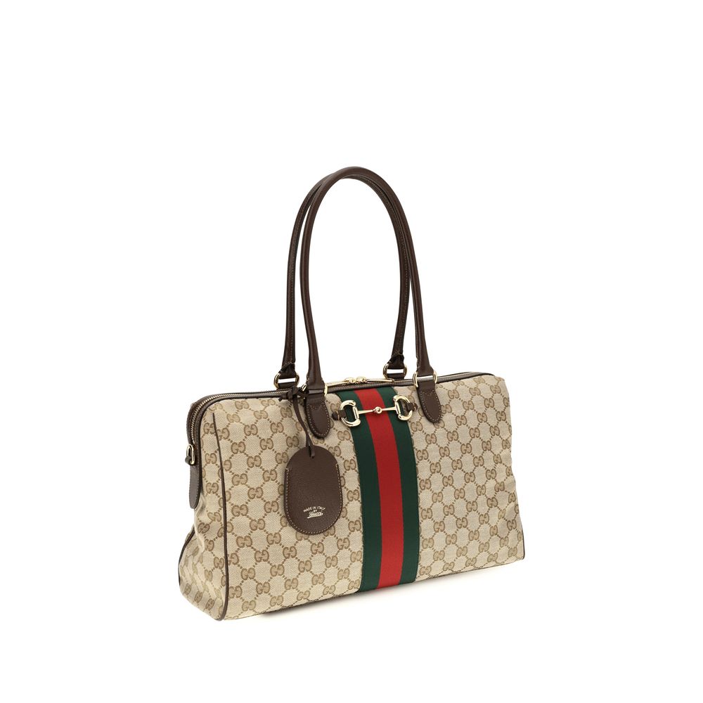 Sac à main en tissu beige de Gucci, élégant et spacieux, avec détails en cuir et logo Gucci visible.