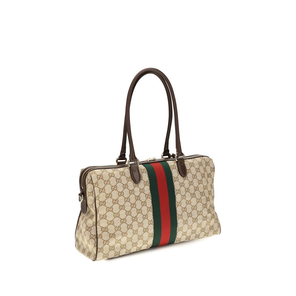 Sac à main en tissu beige Gucci, élégant et sophistiqué, avec détails en cuir et logo distinctif.