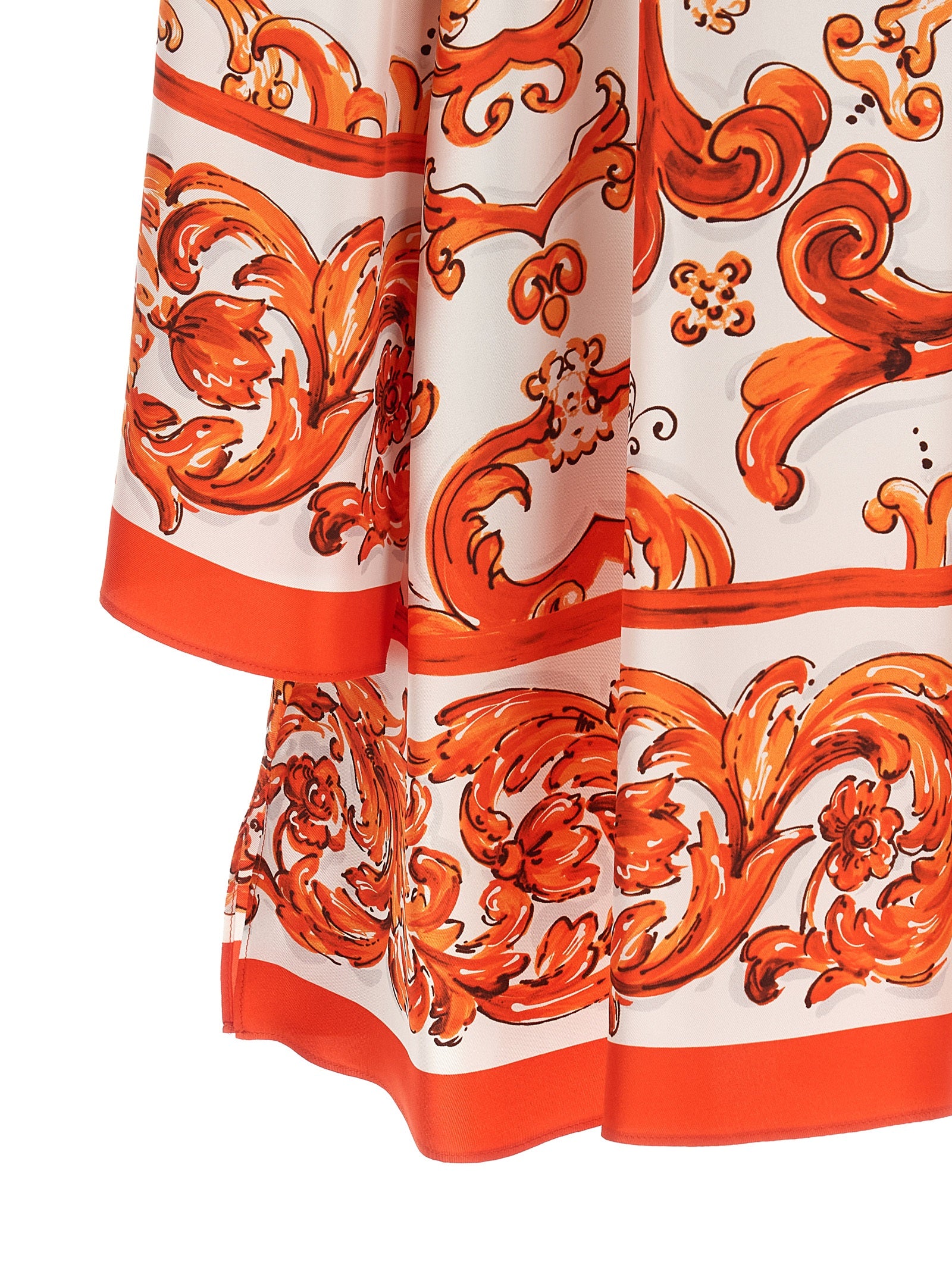 Robe courte en soie orange Dolce & Gabbana avec décolleté et détails élégants, portée sur un mannequin.