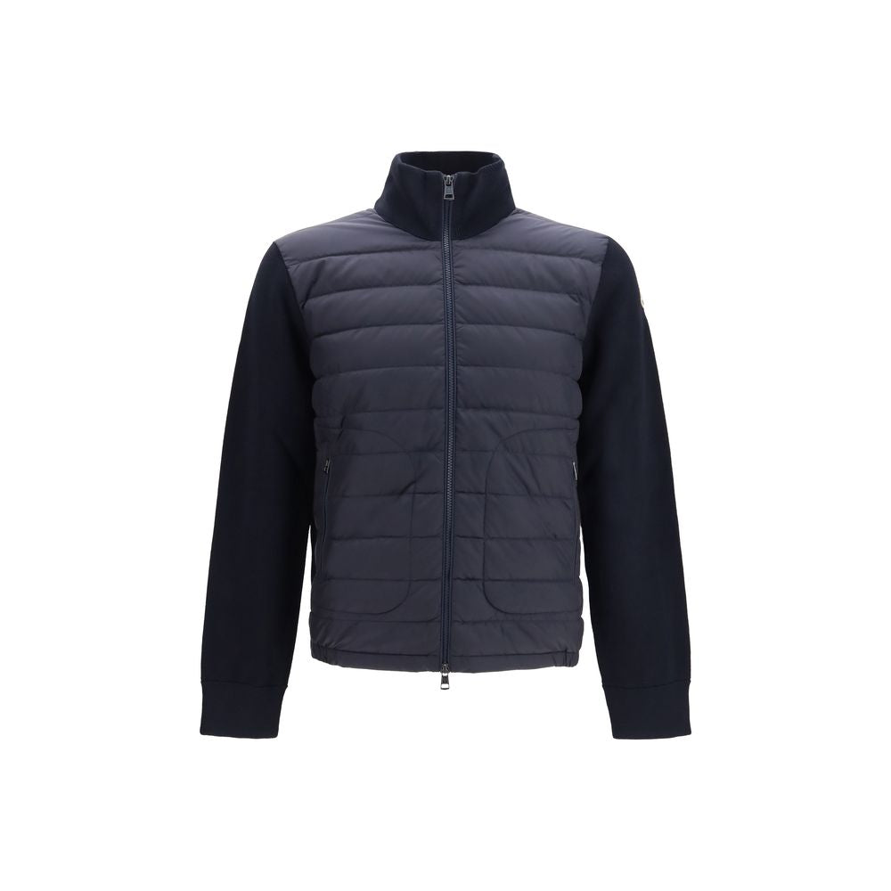 Veste longue en duvet bleu Moncler, avec capuche et fermeture éclair, conçue pour la chaleur et le style hivernal.
