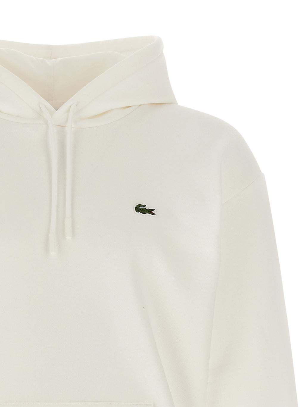 Sweat-shirt blanc en coton de marque Lacoste, avec logo crocodile sur la poitrine, porté dans un style décontracté.