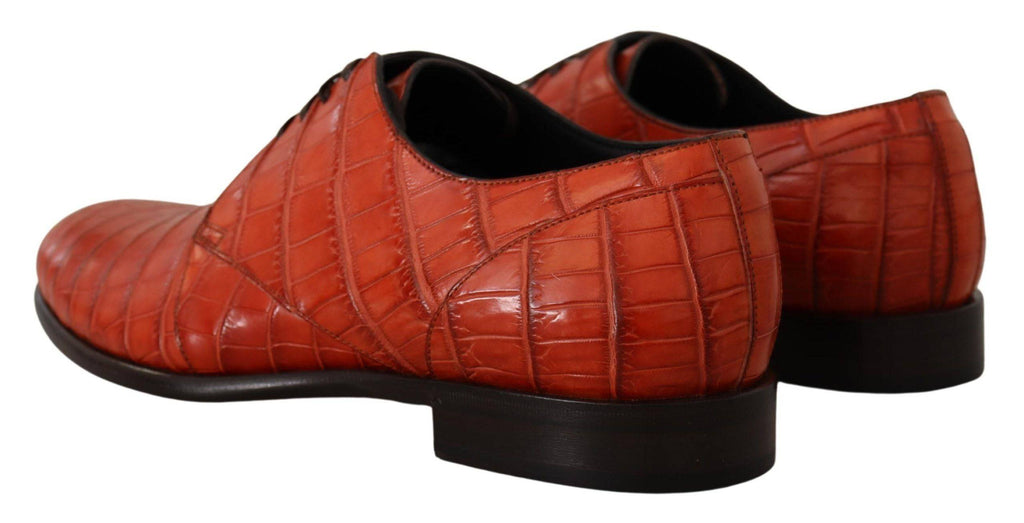 Chaussures derby en cuir exotique orange de Dolce & Gabbana, élégantes et sophistiquées, visibles sous la lumière.