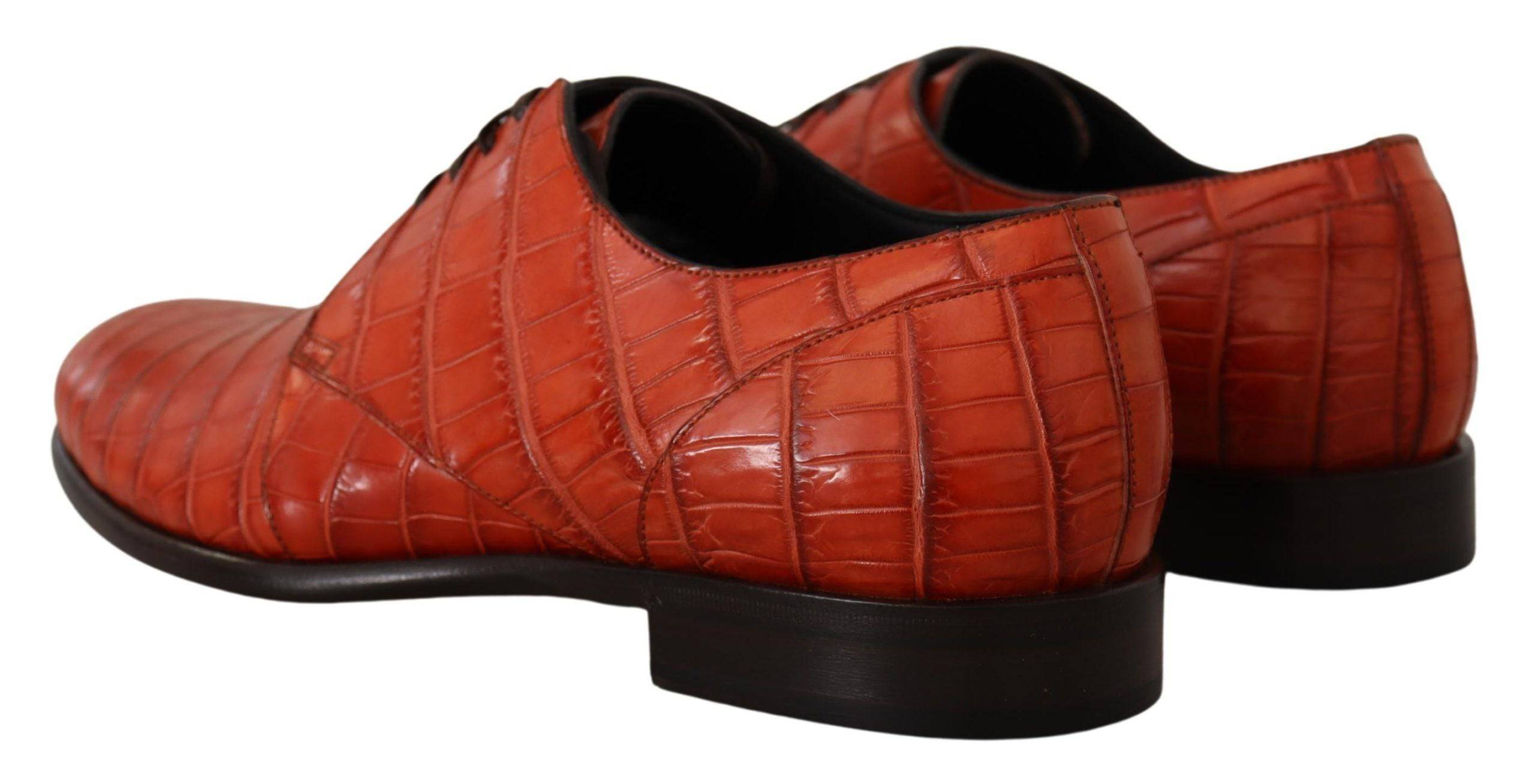 Chaussures derby en cuir exotique orange de Dolce & Gabbana, élégantes et sophistiquées, visibles sous la lumière.