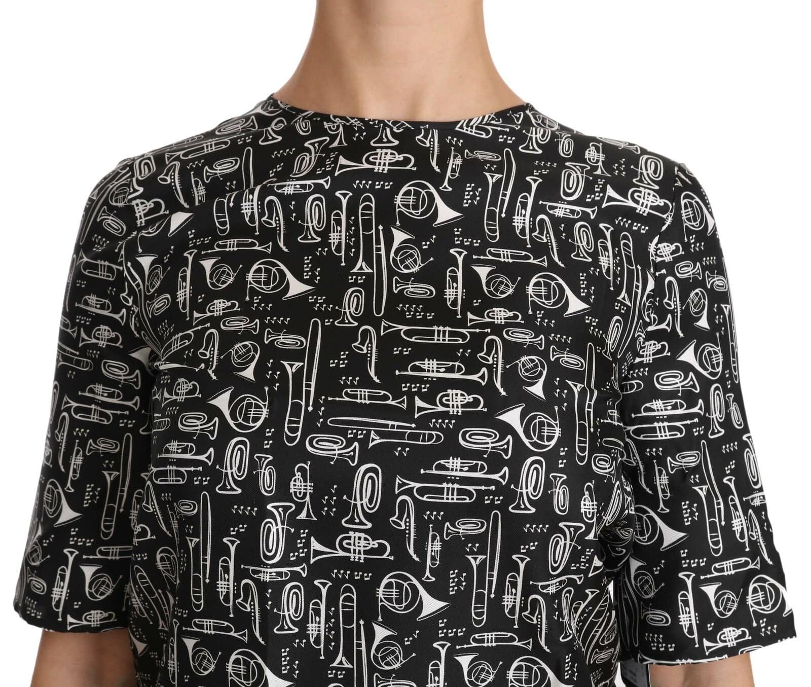 Chemisier en soie noir Dolce & Gabbana avec motif d'instruments de musique, détails élégants et coupe fluide.