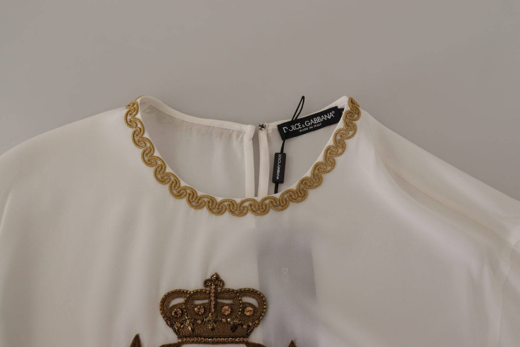 Chemisier blanc en soie Dolce & Gabbana avec broderie en or, détails de couronne en cristal, style élégant et sophistiqué.