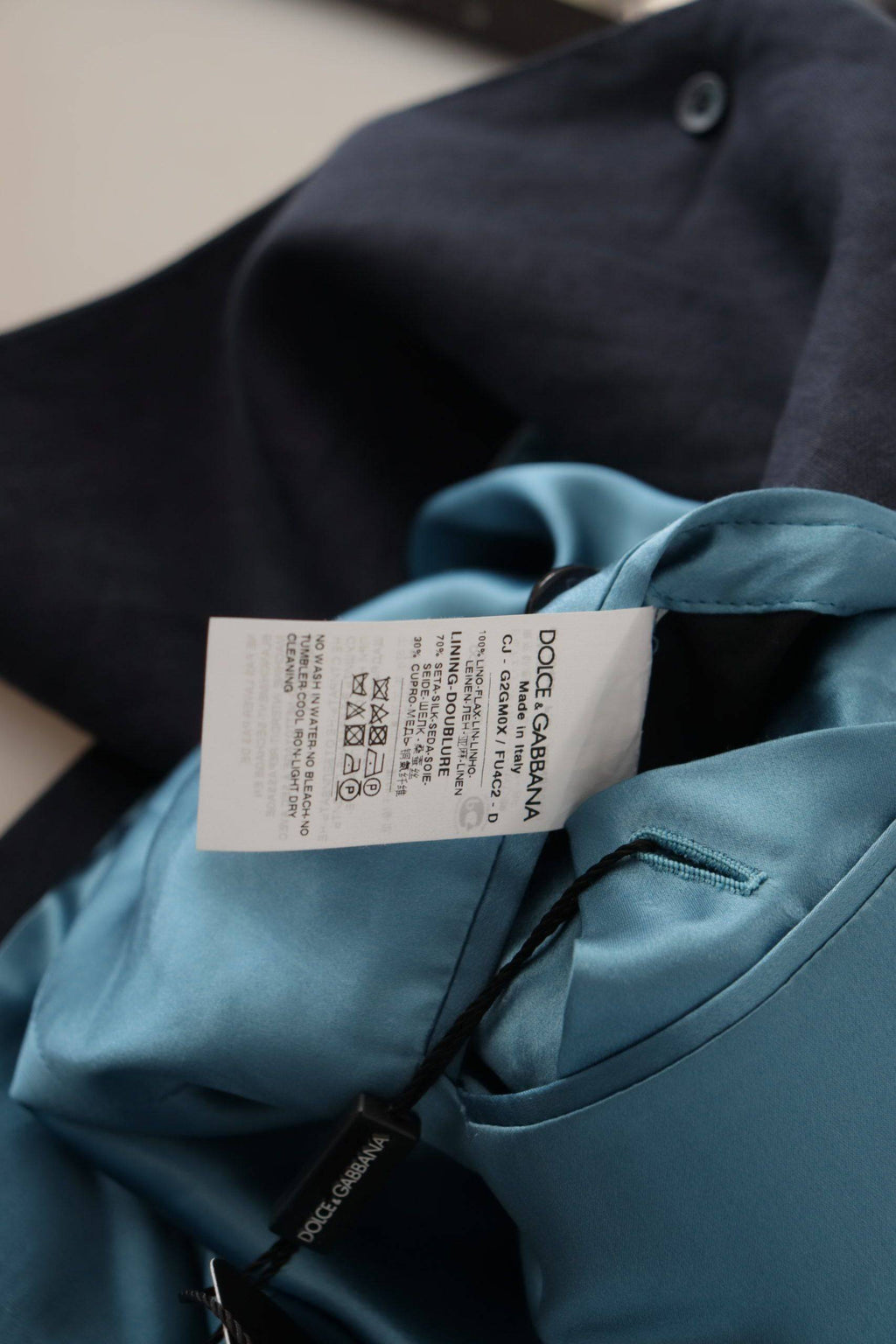 Veste blazer bleue foncée Dolce & Gabbana Alta Sartoria avec détails élégants, portée ouverte sur un fond neutre.