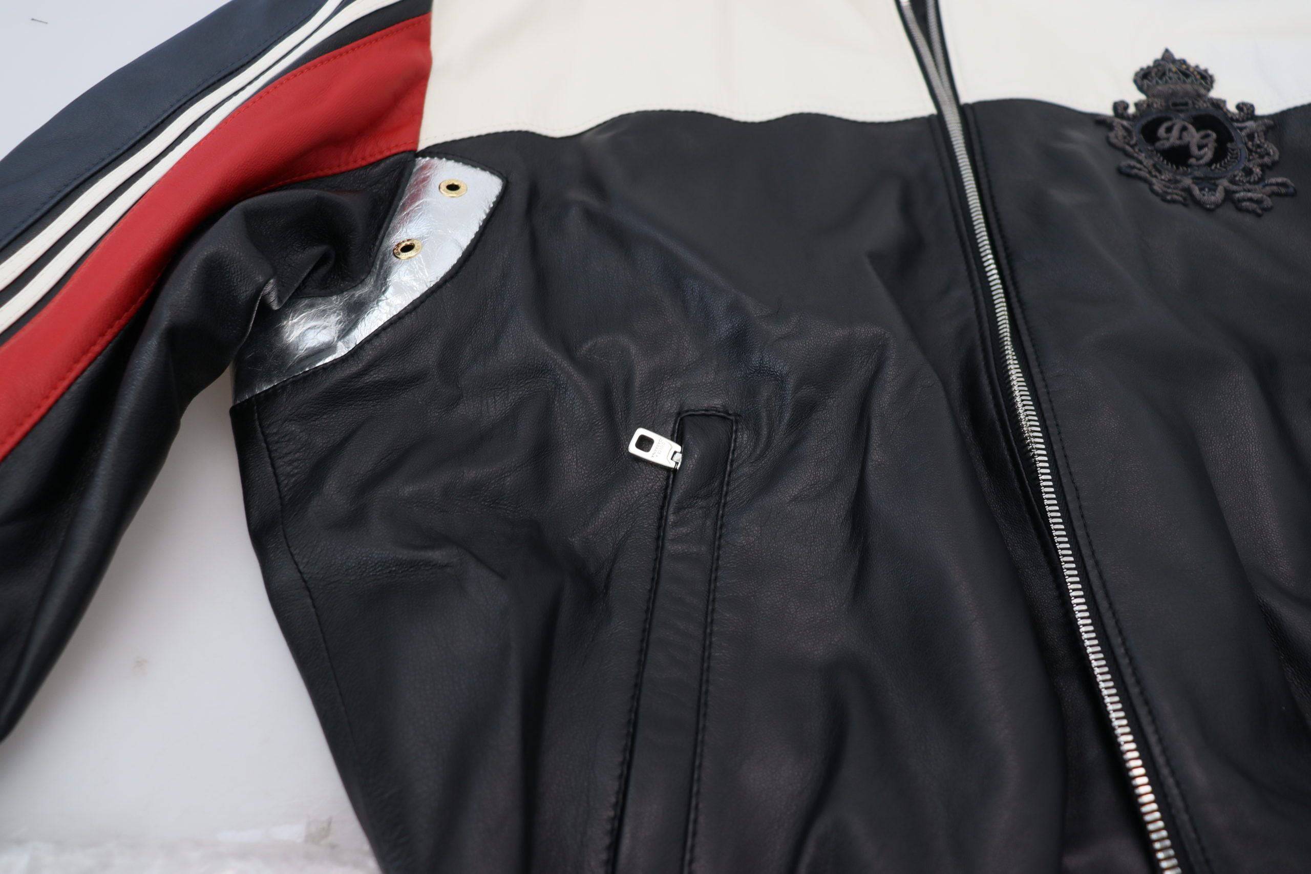Veste blouson en cuir noir Dolce & Gabbana avec capuche, style décontracté et détails élégants, portée en extérieur.