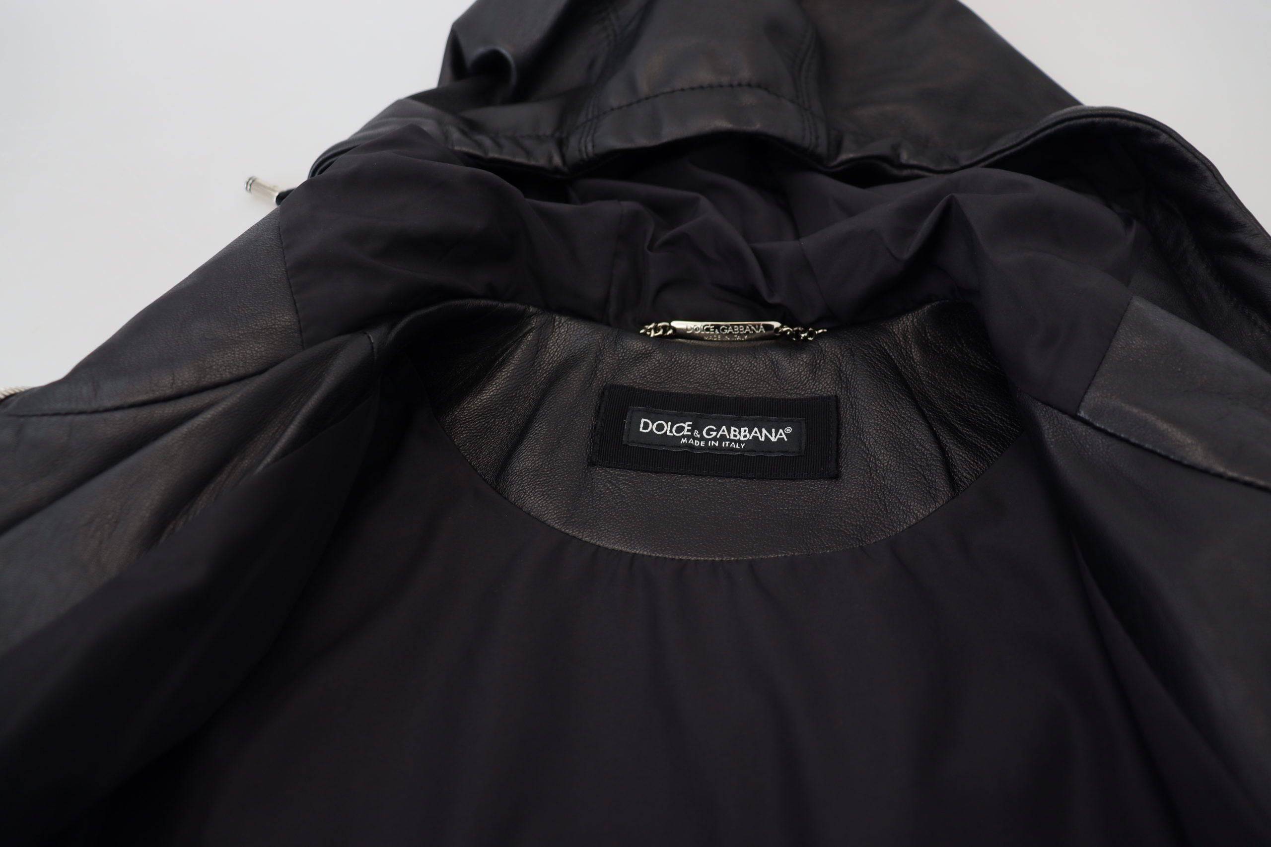 Veste en cuir noir Dolce & Gabbana avec capuche, style blouson, visible en détail sur l'image.