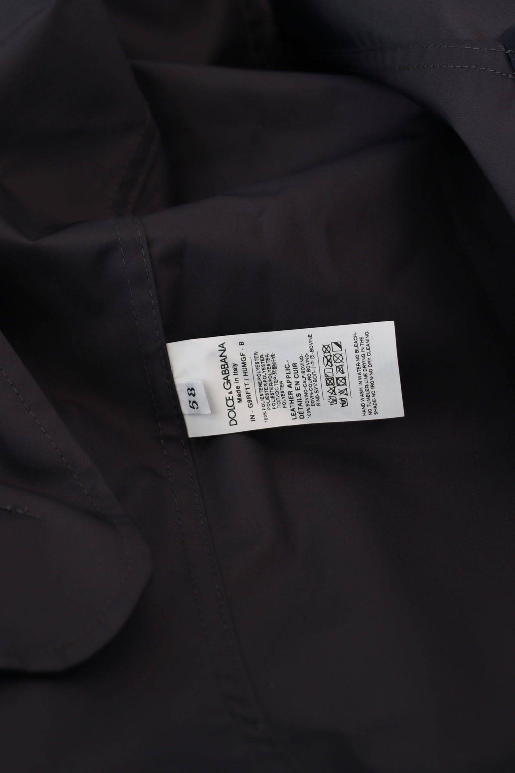 Manteau double boutonnage à capuche bleu Dolce & Gabbana, veste élégante en tissu léger, vue de face sur fond neutre.