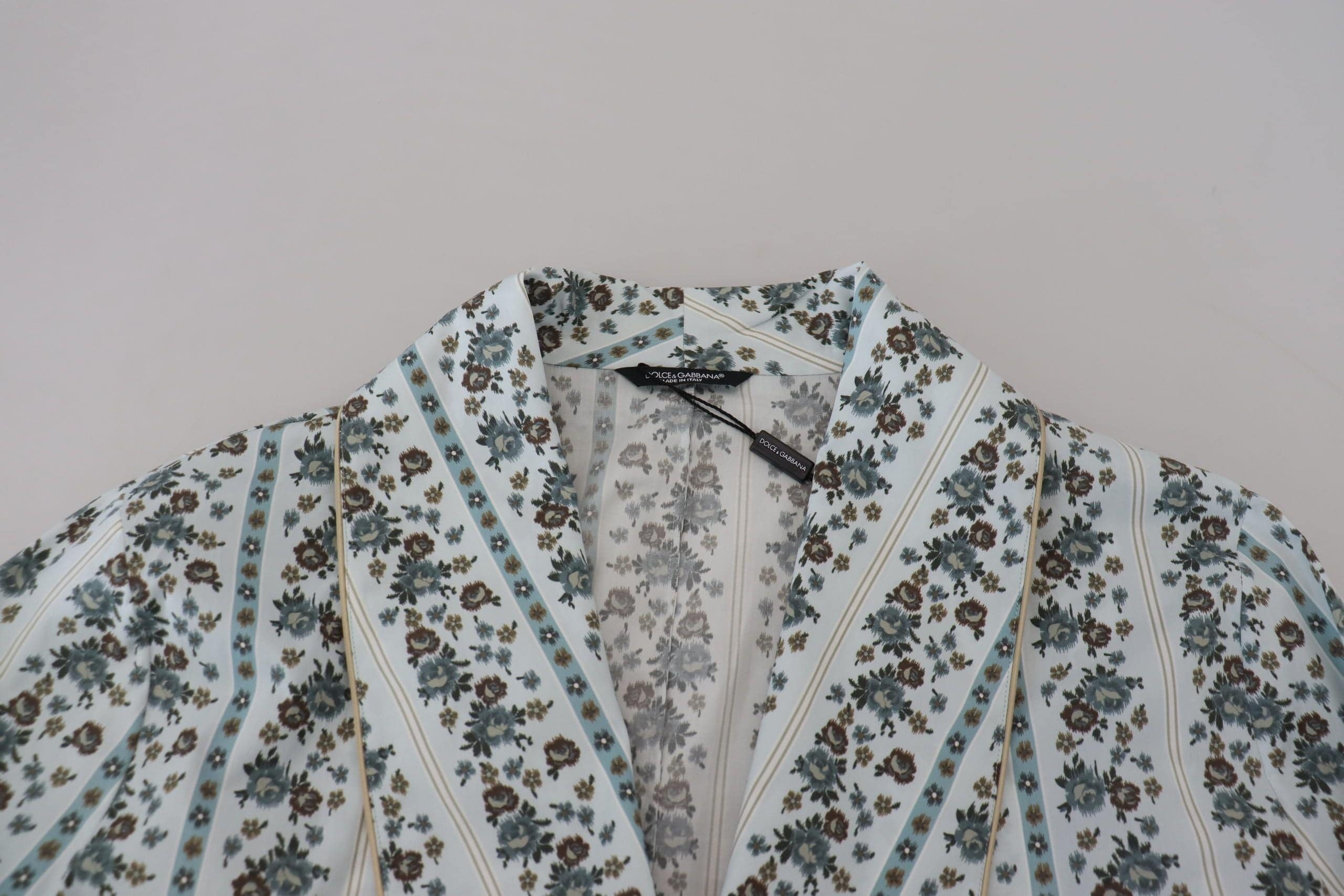 Robe-coat en coton à fleurs bleues de Dolce & Gabbana avec coupe élégante et détails floraux visibles sur l'image.