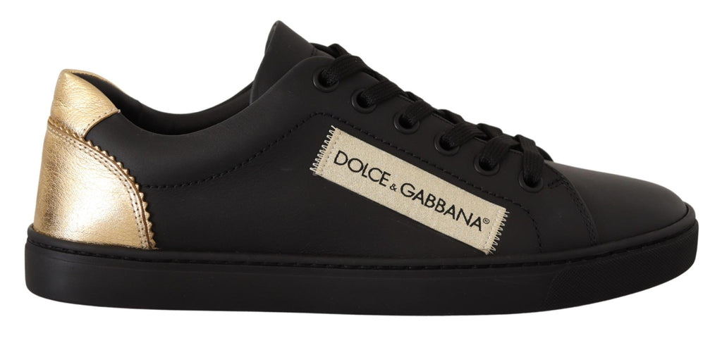 Sneakers bass en cuir noir et or Dolce & Gabbana pour femmes, avec logo et semelle blanche dans une image en gros plan.
