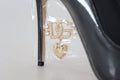 Escarpins en cuir noir de Dolce & Gabbana avec emballage plastique, talons élégants et design sophistiqué.