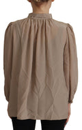 Blouse Dolce & Gabbana en brun avec col ascot, manches à bandeau à la taille, style élégant et sophistiqué.