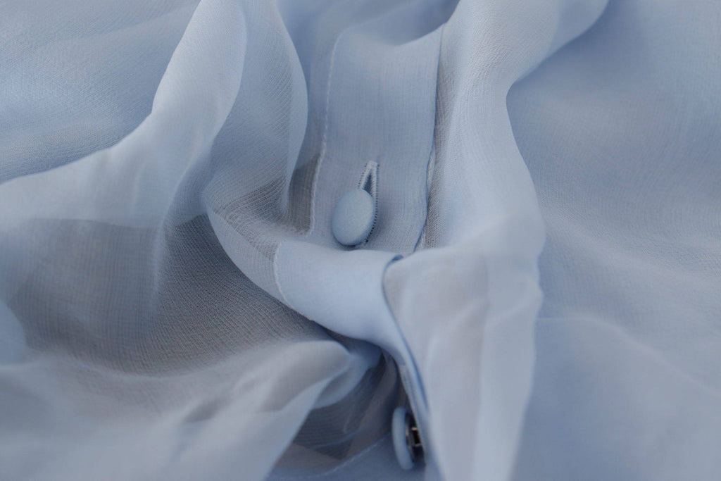 Haut en soie Light Blue de Dolce & Gabbana avec col ascot et manches longues, élégance sophistiquée.