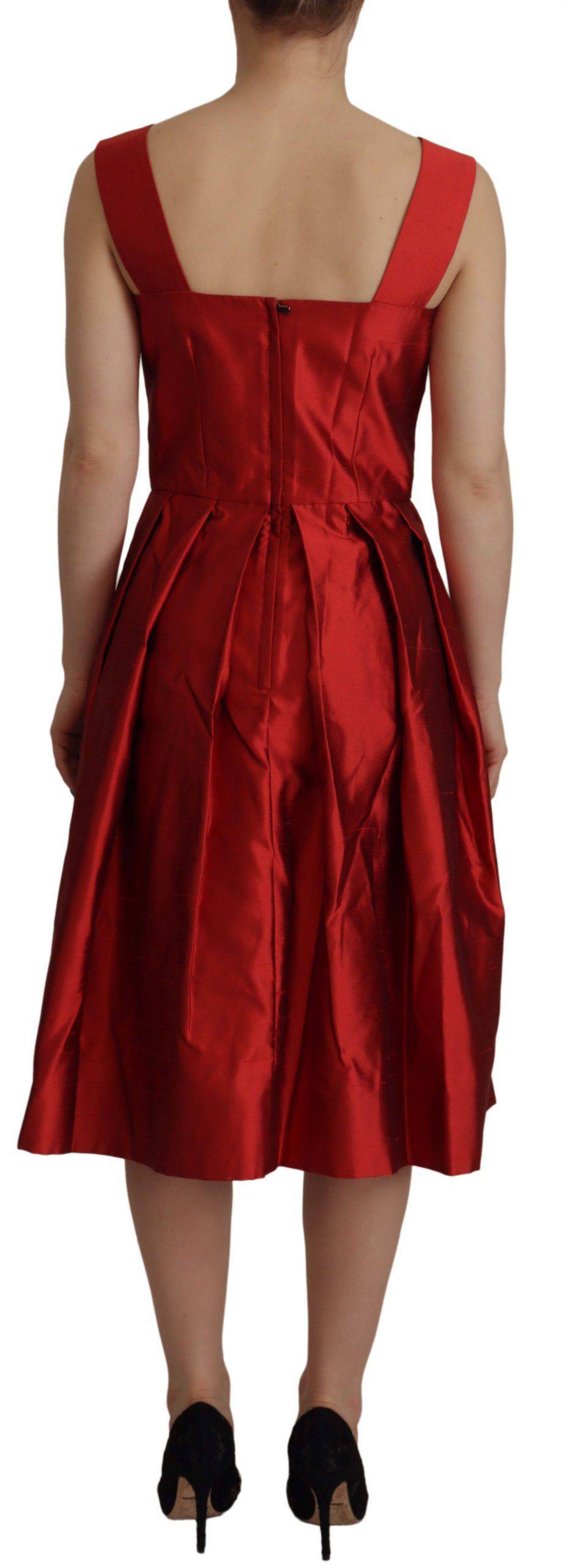 Robe en satin rouge à plis en A de Dolce & Gabbana, élégante et sophistiquée, visible avec un style fluide et brillant.