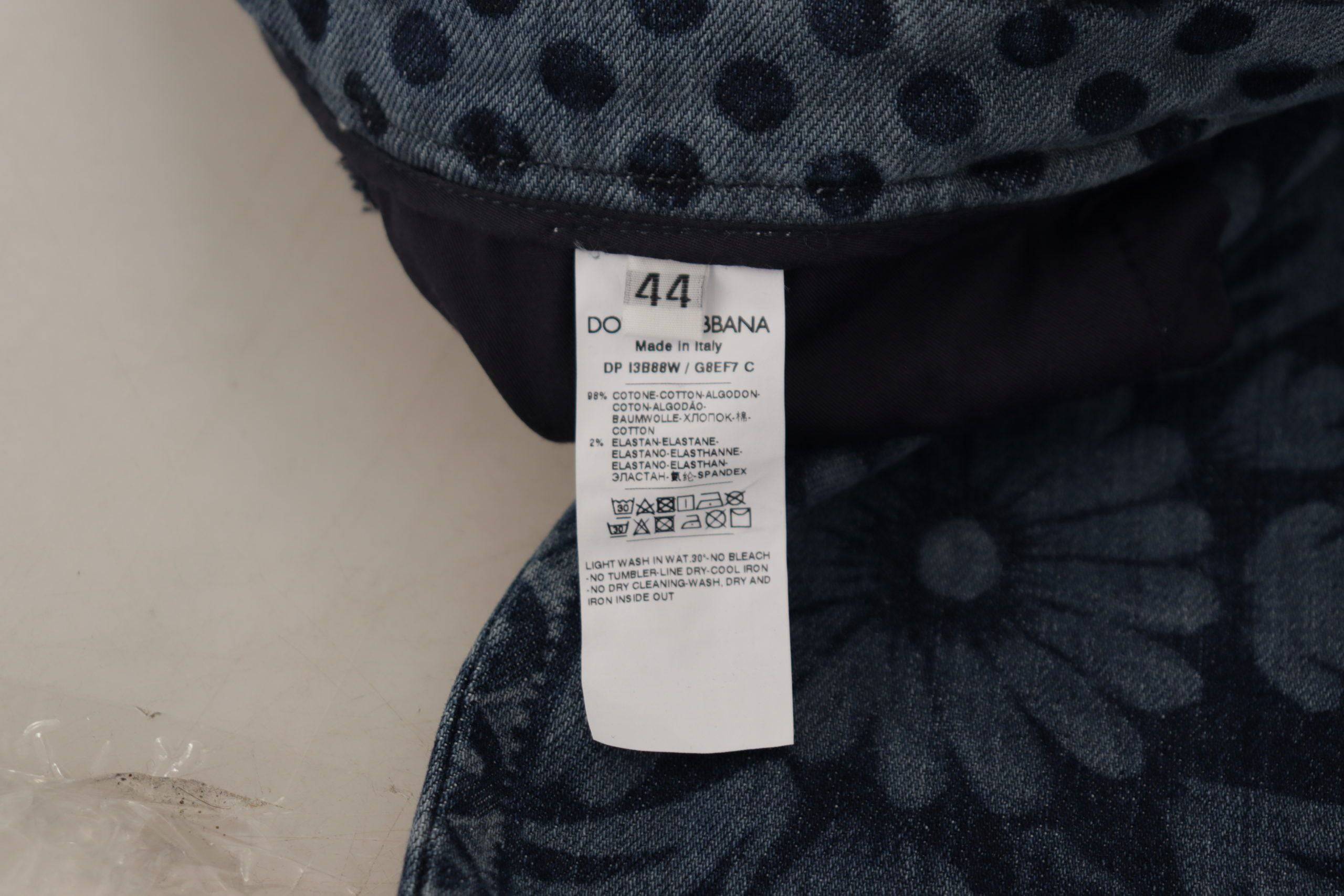 Jeans skinny en denim bleu à taille haute de Dolce & Gabbana avec motif floral, visibles sur l’image.