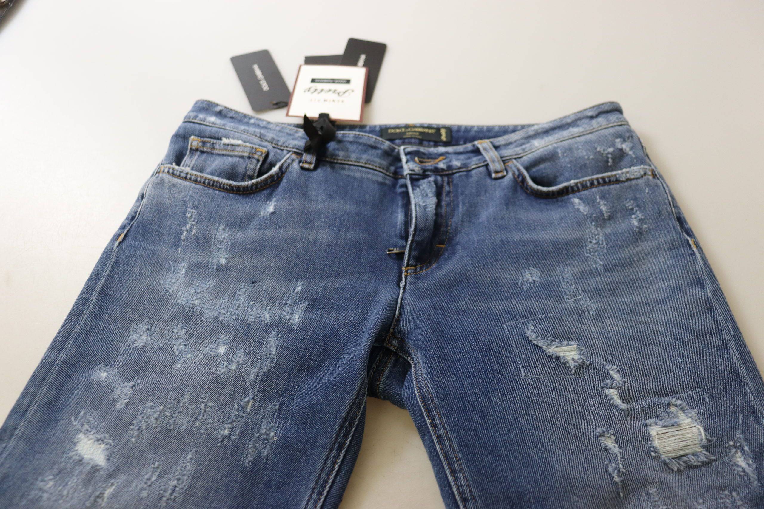 Jeans skinny en denim coton lavé bleu à taille basse de Dolce & Gabbana, visibles avec détails de couture et bouton.